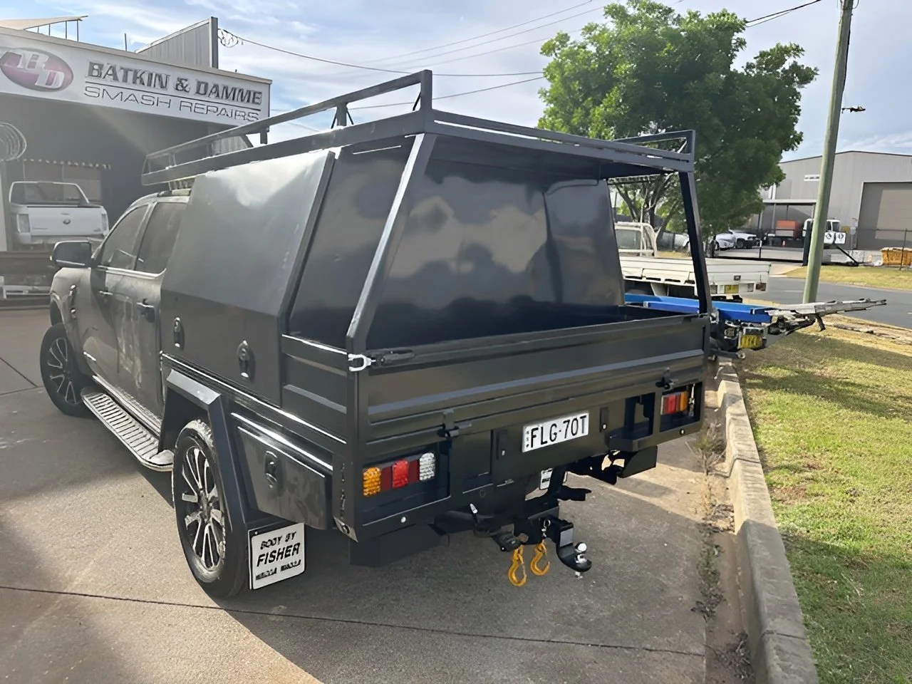 Black utility truck with a canopy and towing equipment, custom fabricated ute tray flatbed. Powder coated and sandblasted, and installed. Custom designed and welded ute tray.