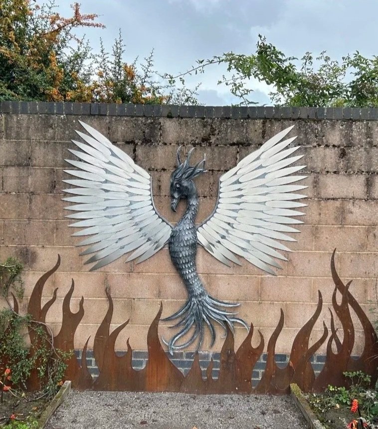 Metal phoenix sculpture mounted to a wall at RSPB Saltholme