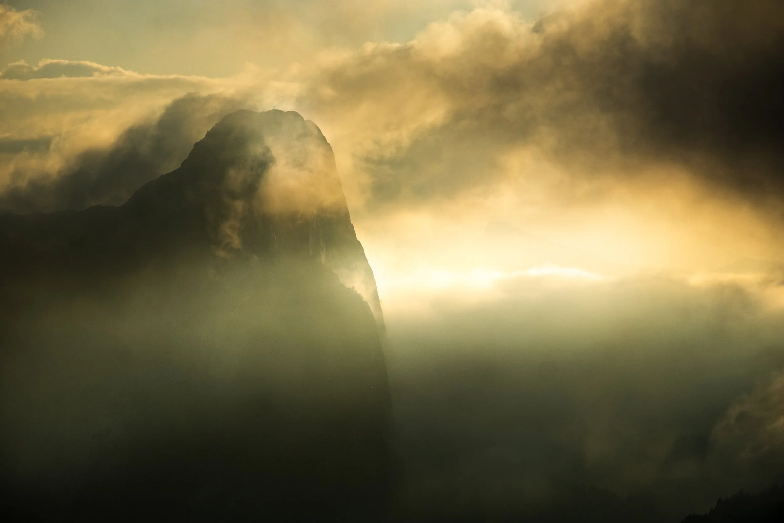 Les derniers rayons du soleil percent les nuages et viennent buter contre l'immense face nord du Mont Chauffé (2093m)