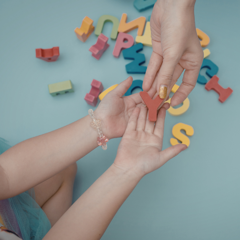 Mano della mamma che offre la lettera Y a un bambino per il percorso di Apprendimento Precoce