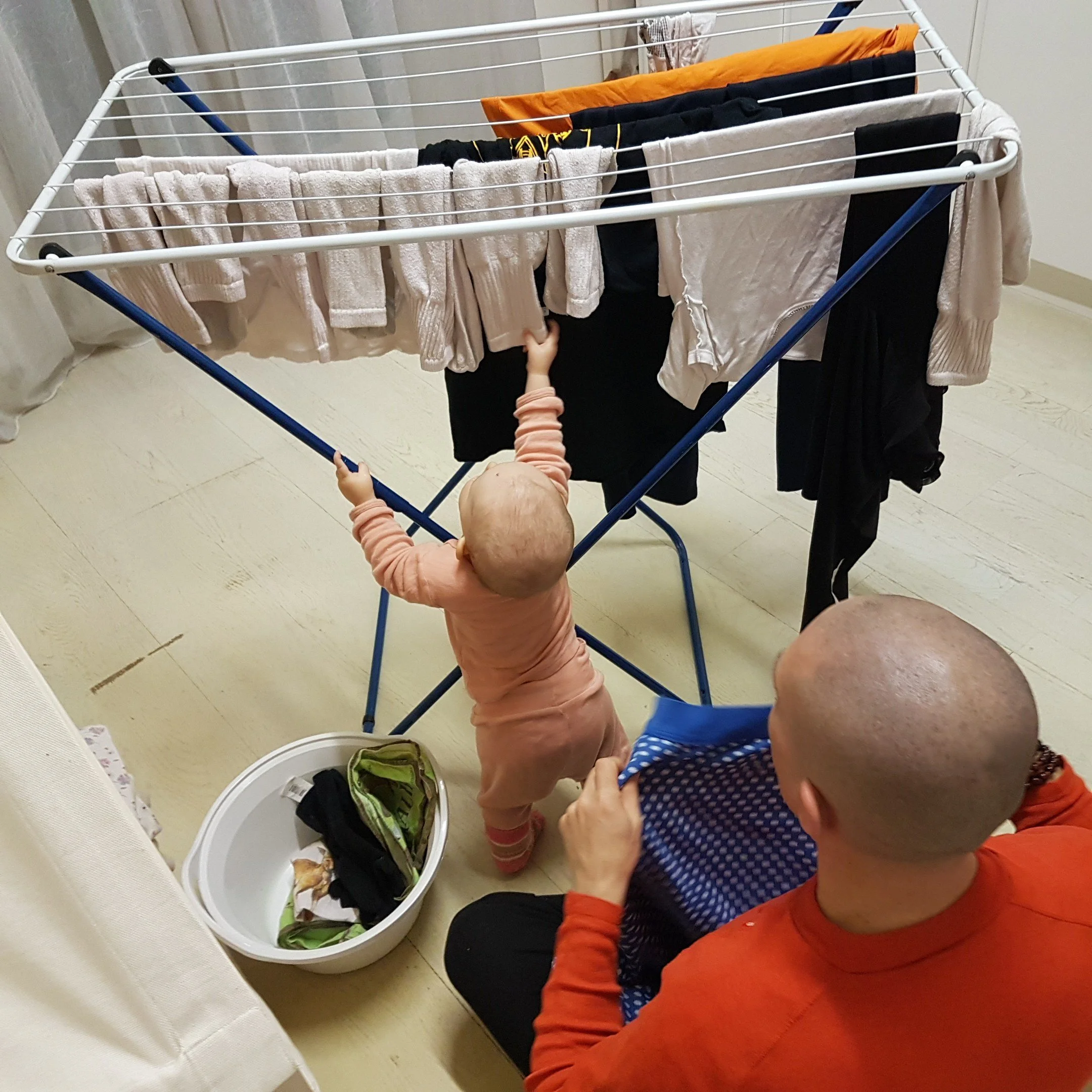 Padre che segue e osserva la figlia neonata durante un'attività di vita pratica e sviluppo infantile