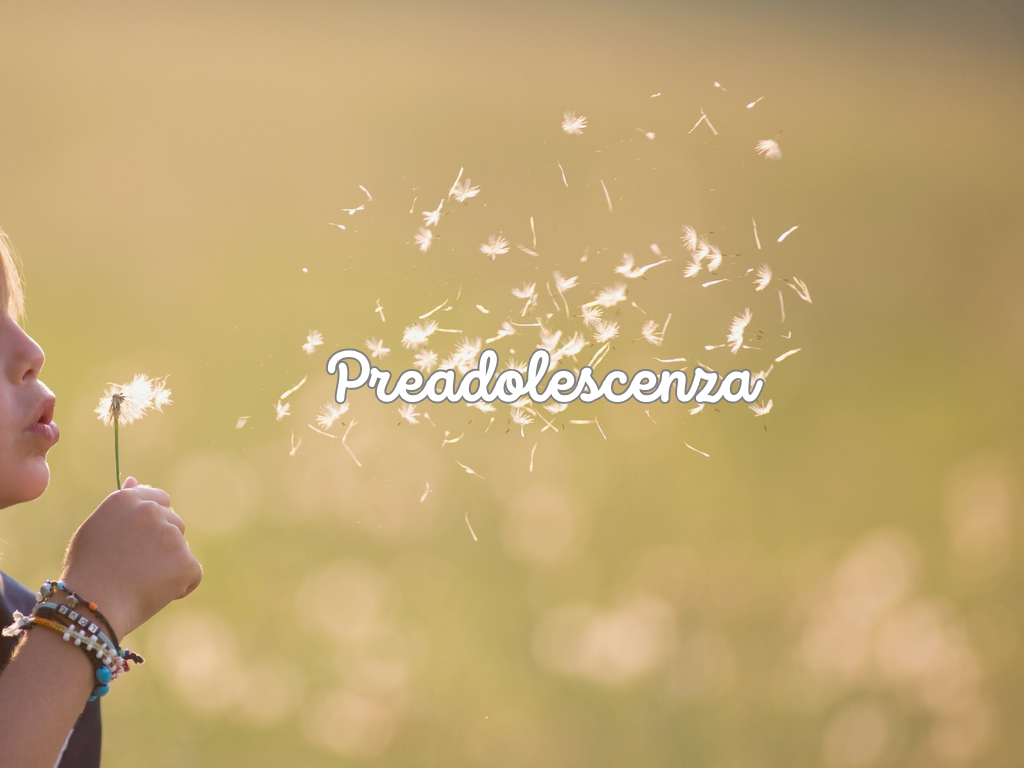 Preadolescente che soffia un soffione 