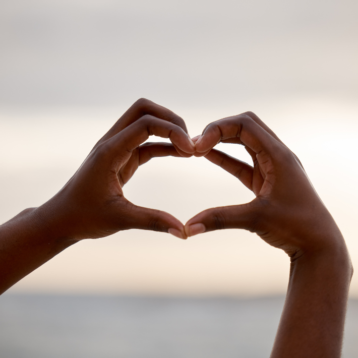 Due mani che formano un cuore con le dita per il percorso di Self-Care e benessere genitoriale