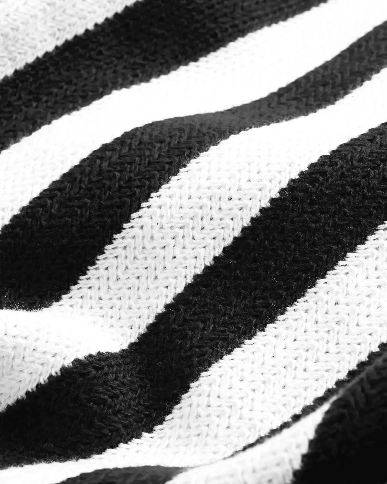 Close-up of black and white striped fabric with racked knit texture.