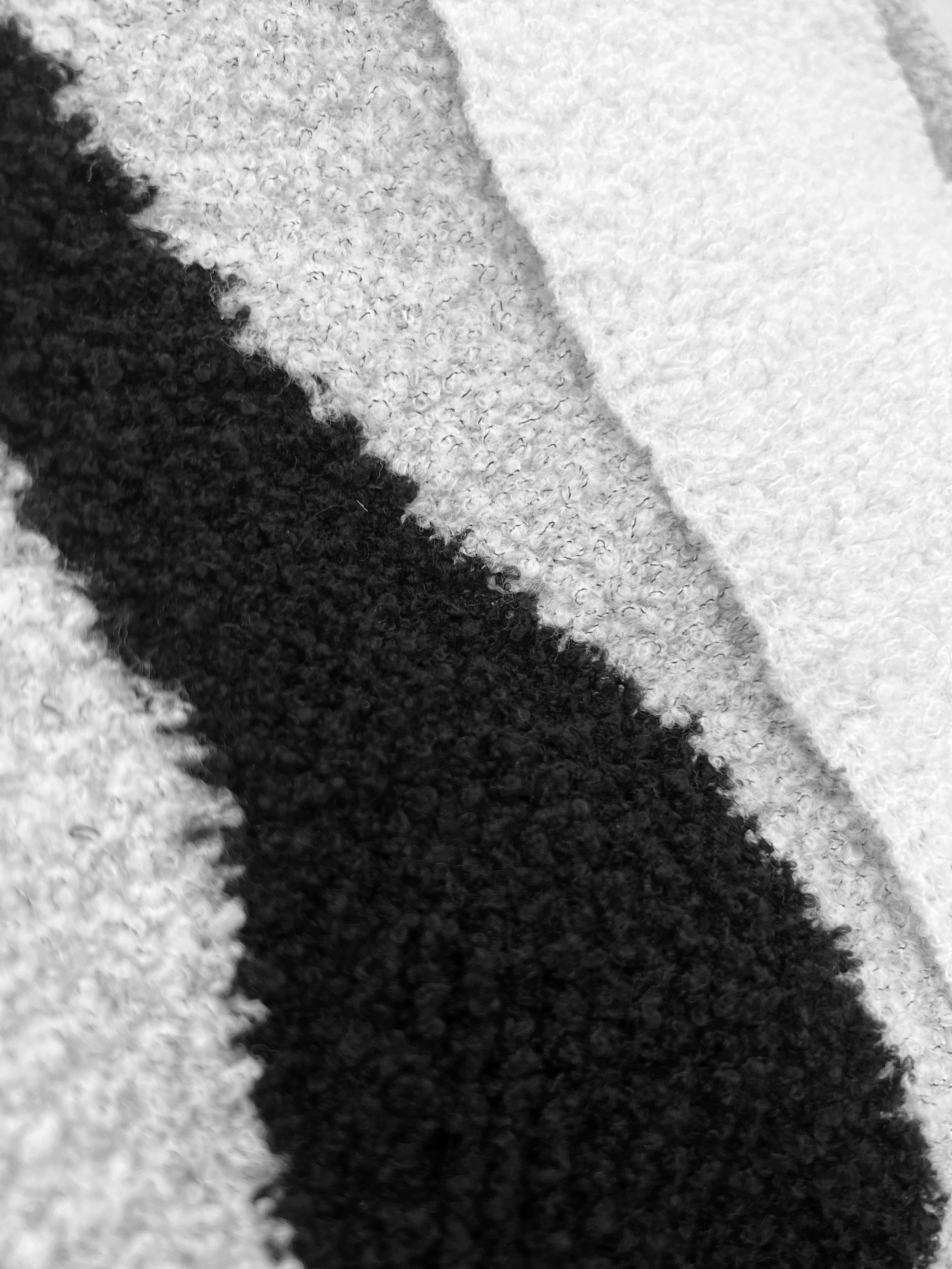 Close-up of textured fabric with bold black and white stripe pattern.
