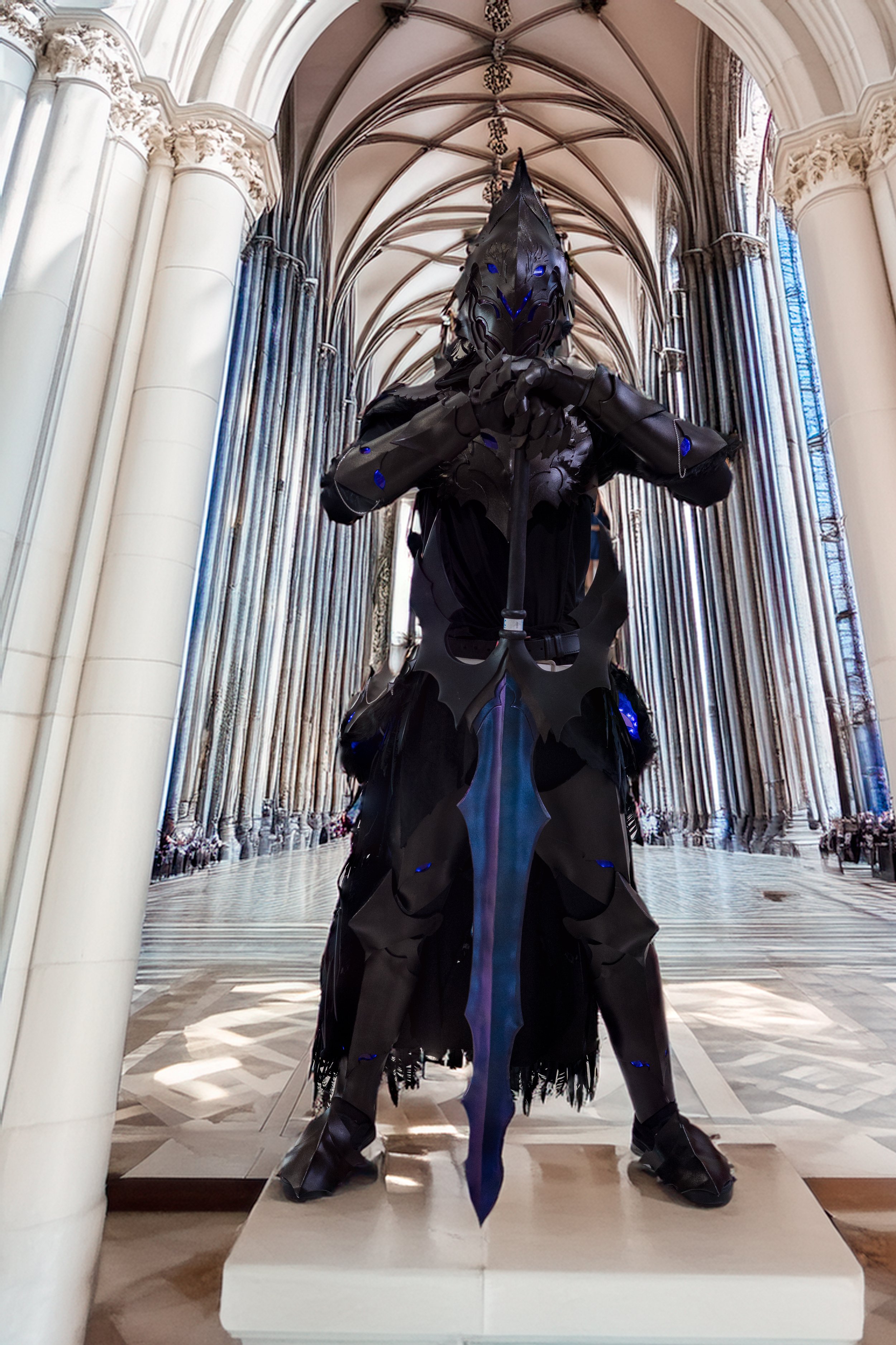 A person dressed in black armor with a horned helmet, standing in a cathedral with tall arches and stained glass windows.