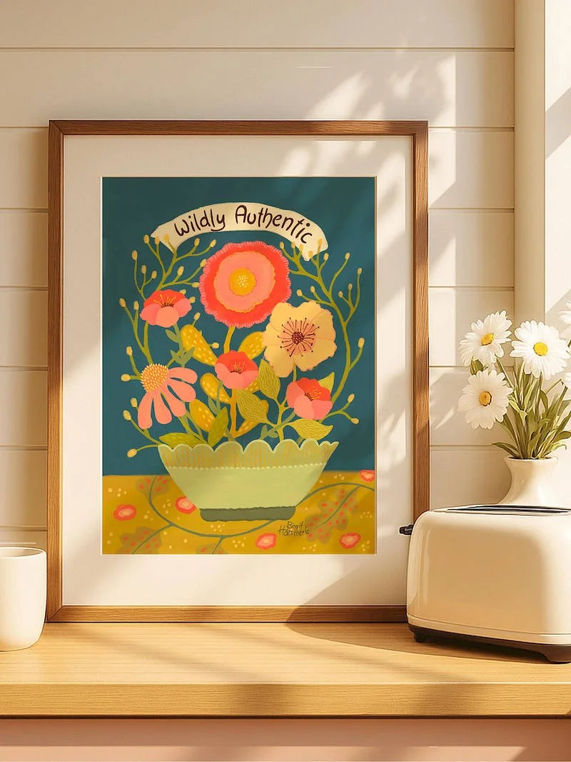 A cheerful illustrated art print featuring a bouquet of colourful wildflowers in a scalloped bowl, set against a deep teal background with the words "Wildly Authentic" on a ribbon banner.