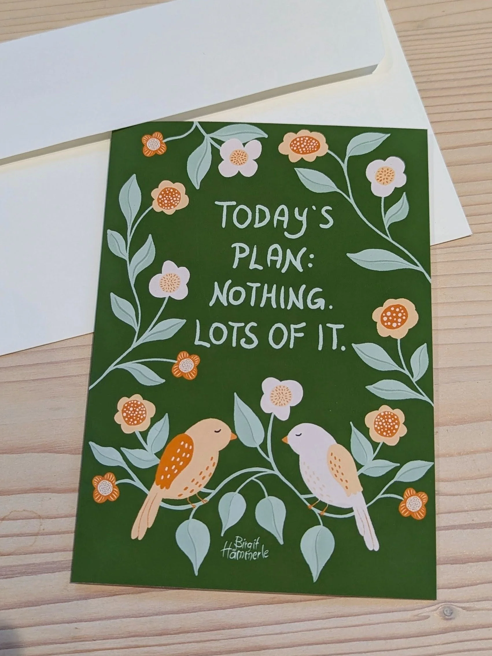 Whimsical greeting card featuring two birds resting among pale blue-green leaves and soft peach flowers. The hand-lettered message reads 'Today's plan: Nothing. Lots of it.'