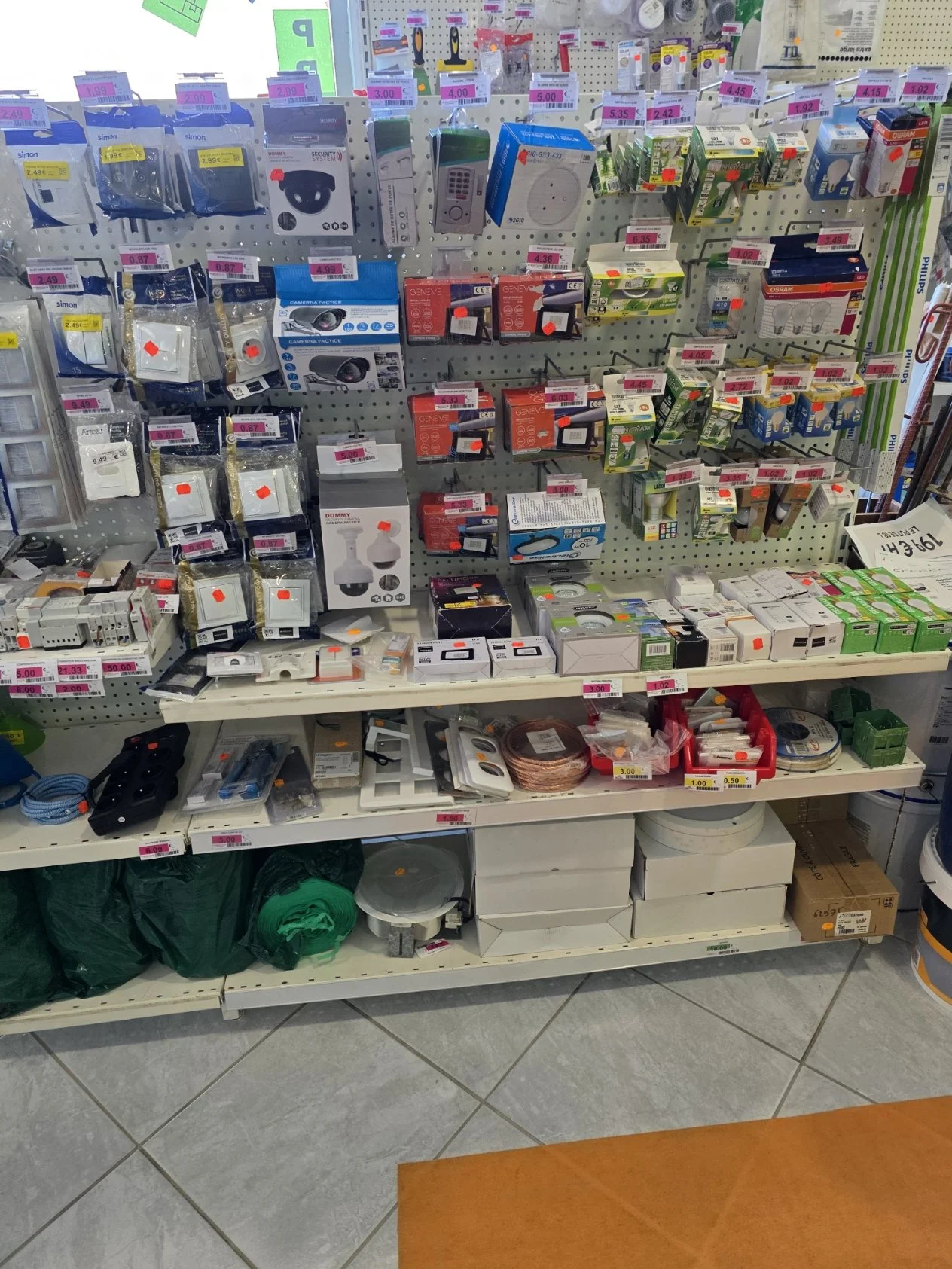 Rayon de quincaillerie avec divers produits électriques, prises, câbles, interrupteurs, et accessoires pour la maison.