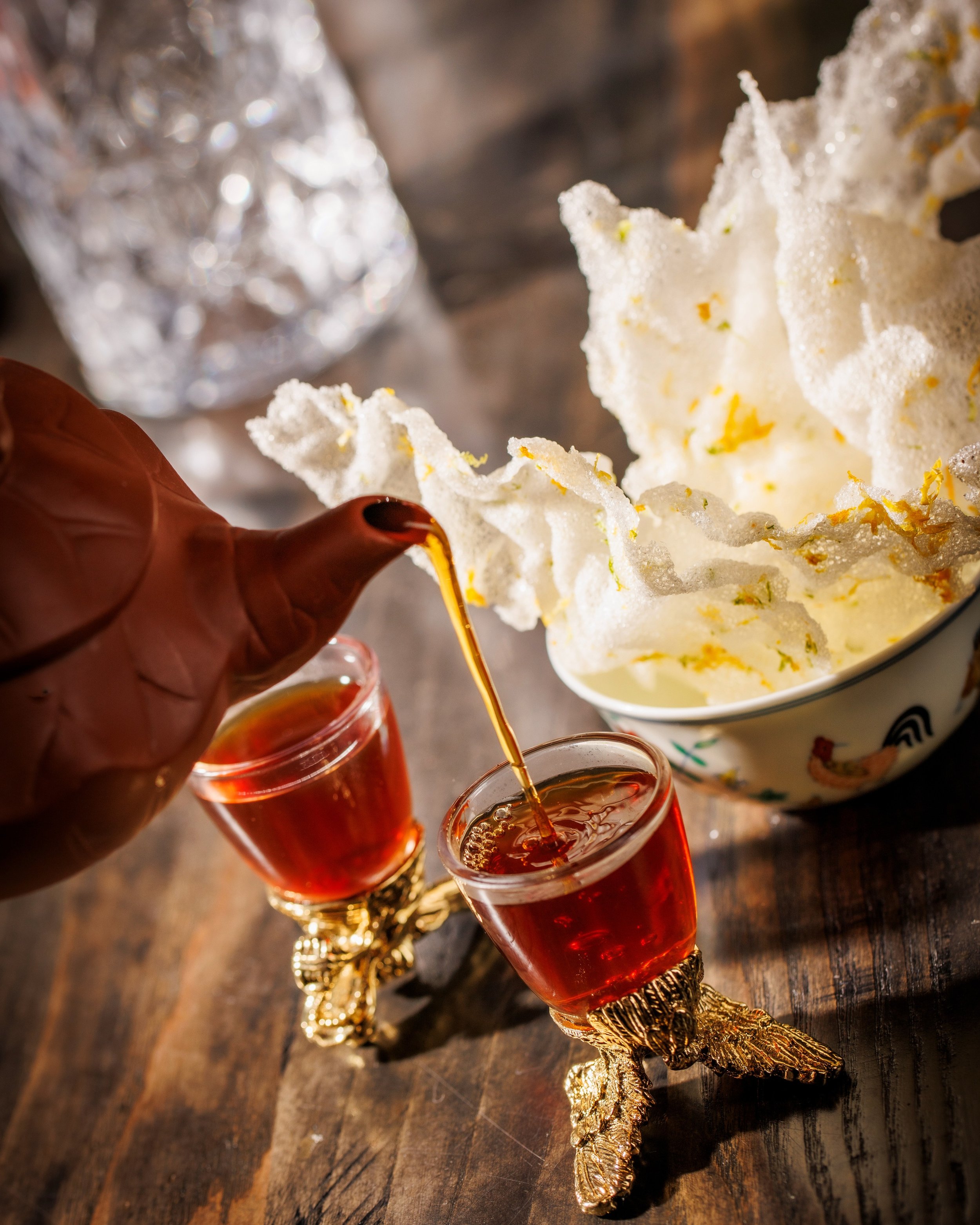 Our Tea Duck Consumme. Deeply savory and finished with a slow burn that builds with every sip. The delicate rice crisps add the perfect shatter of texture&mdash;light, crisp, and just salty enough to keep you reaching for another piece. A signature w
