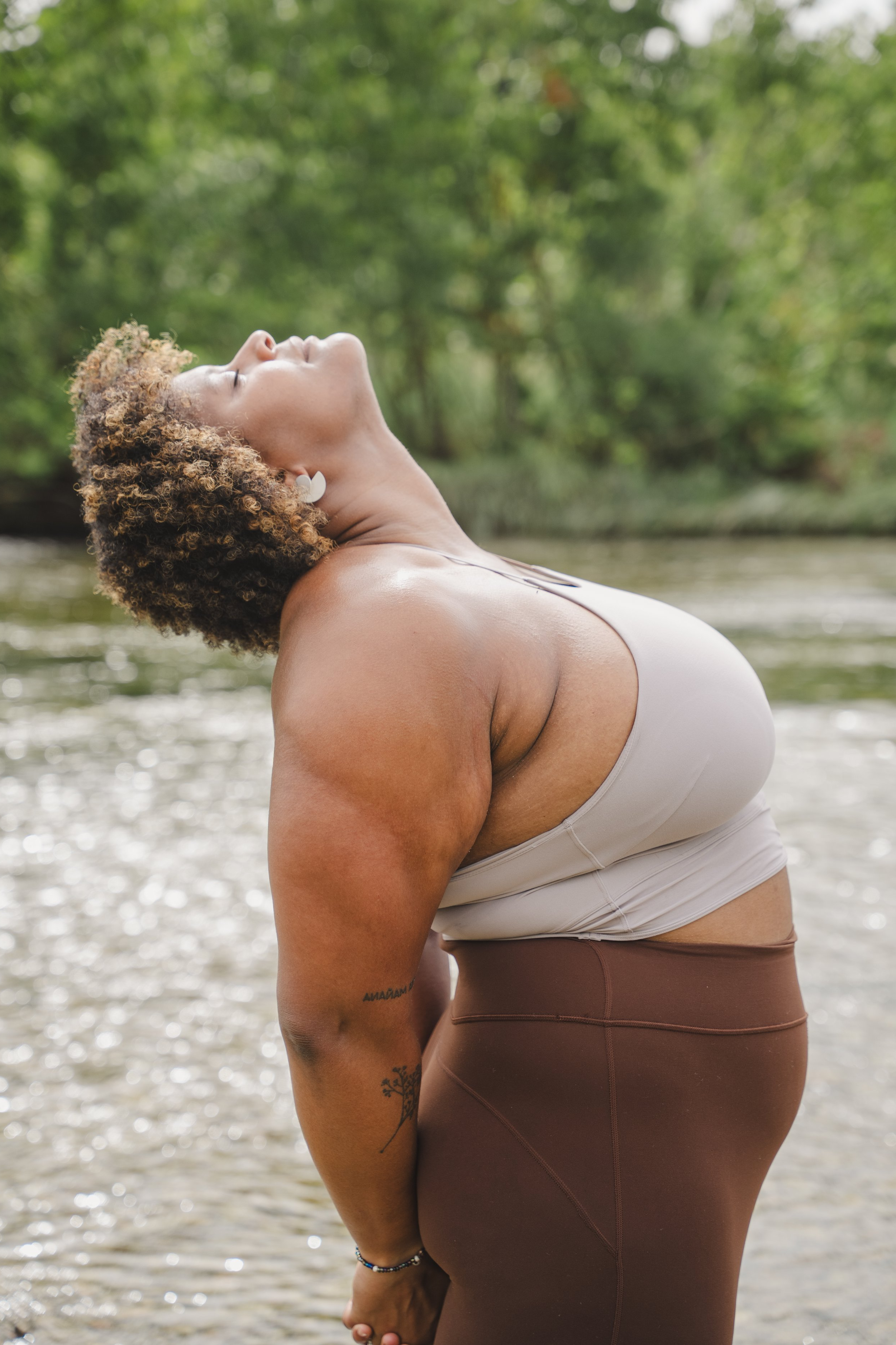 kaila in a backbend with arms behind back, looking up with eyes closed