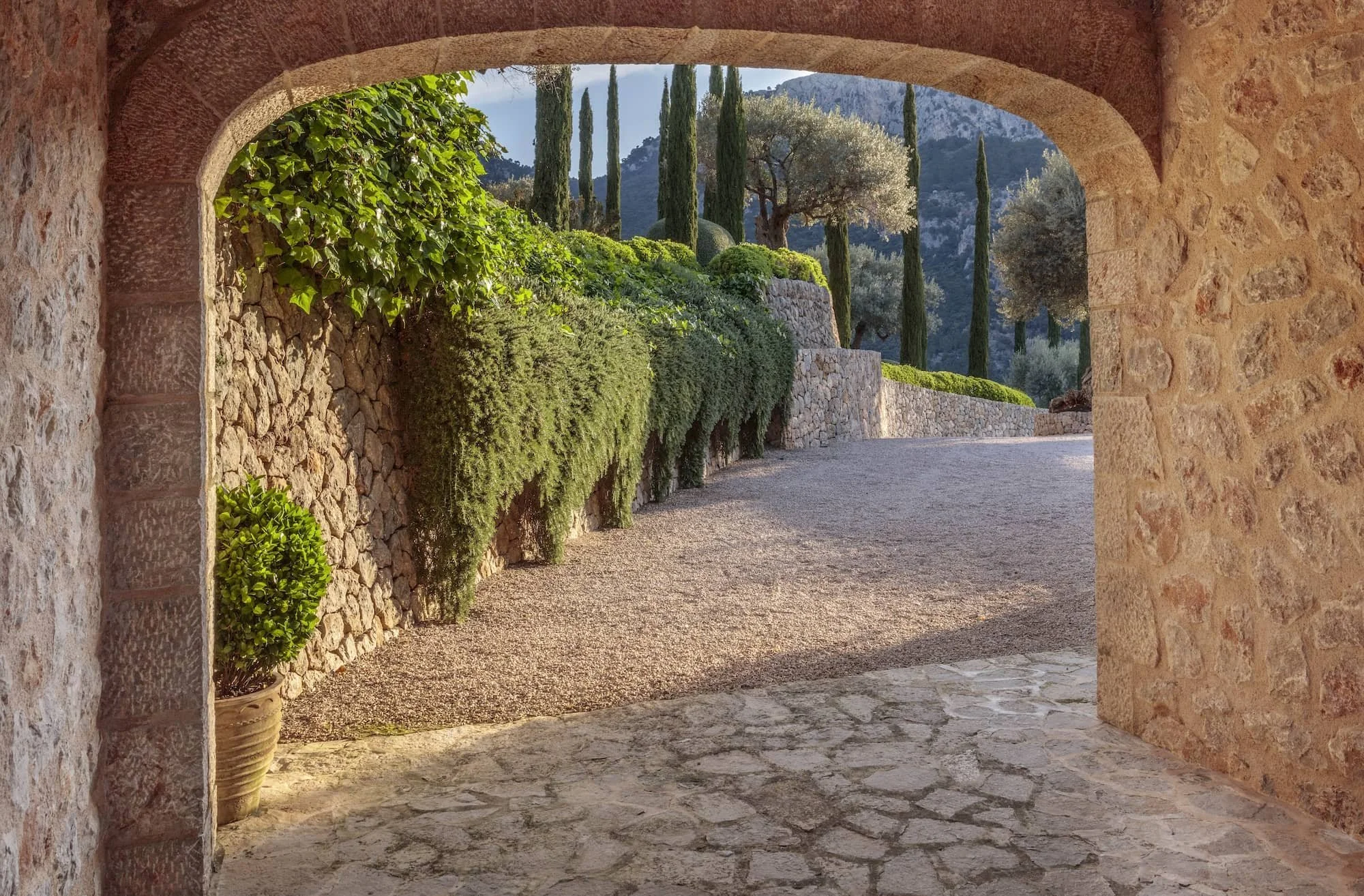 Stone archway framing a garden view in Mallorca's Tramuntana mountains