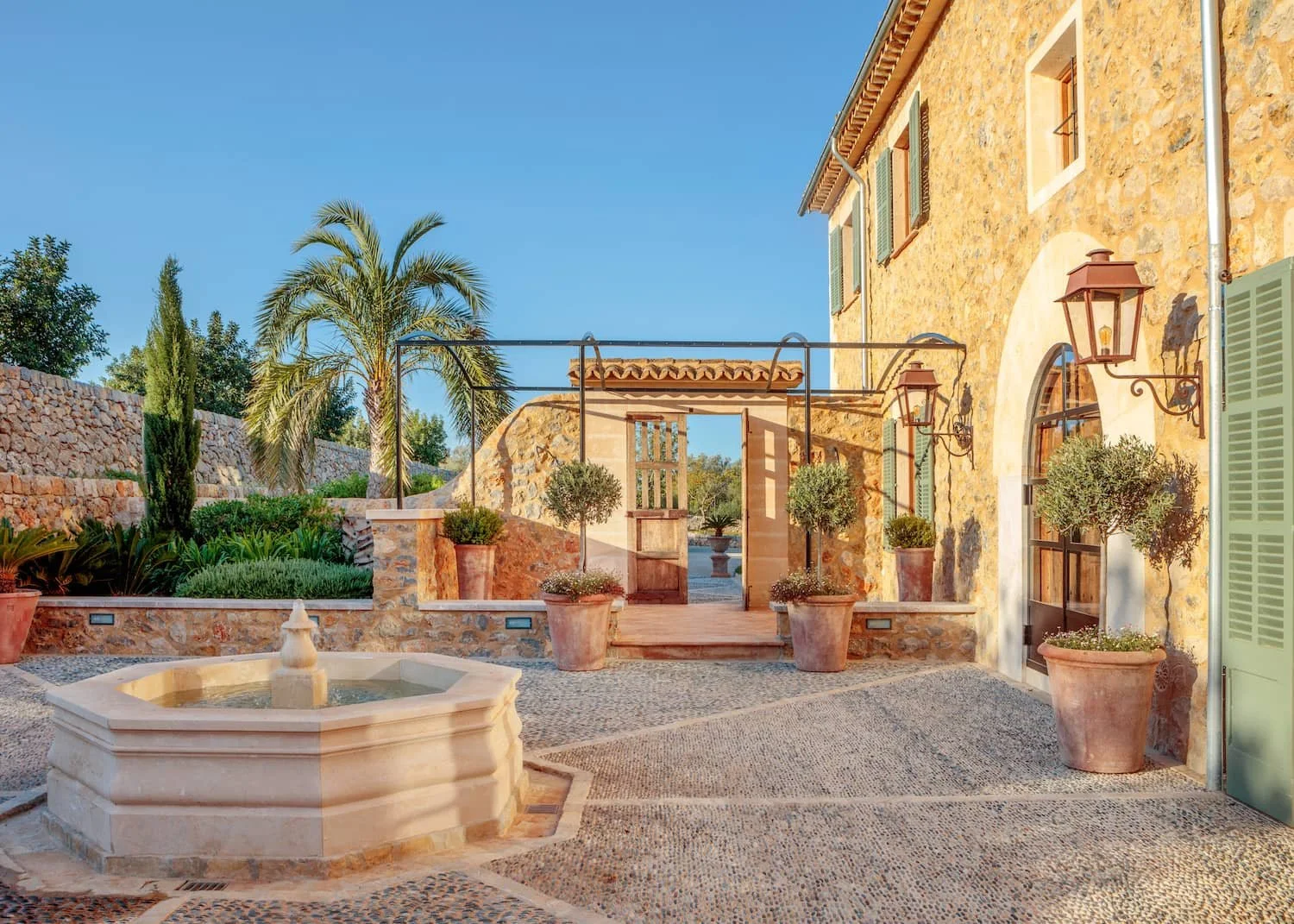 Mediterranean finca courtyard with stone fountain and terracotta pots, Mallorca