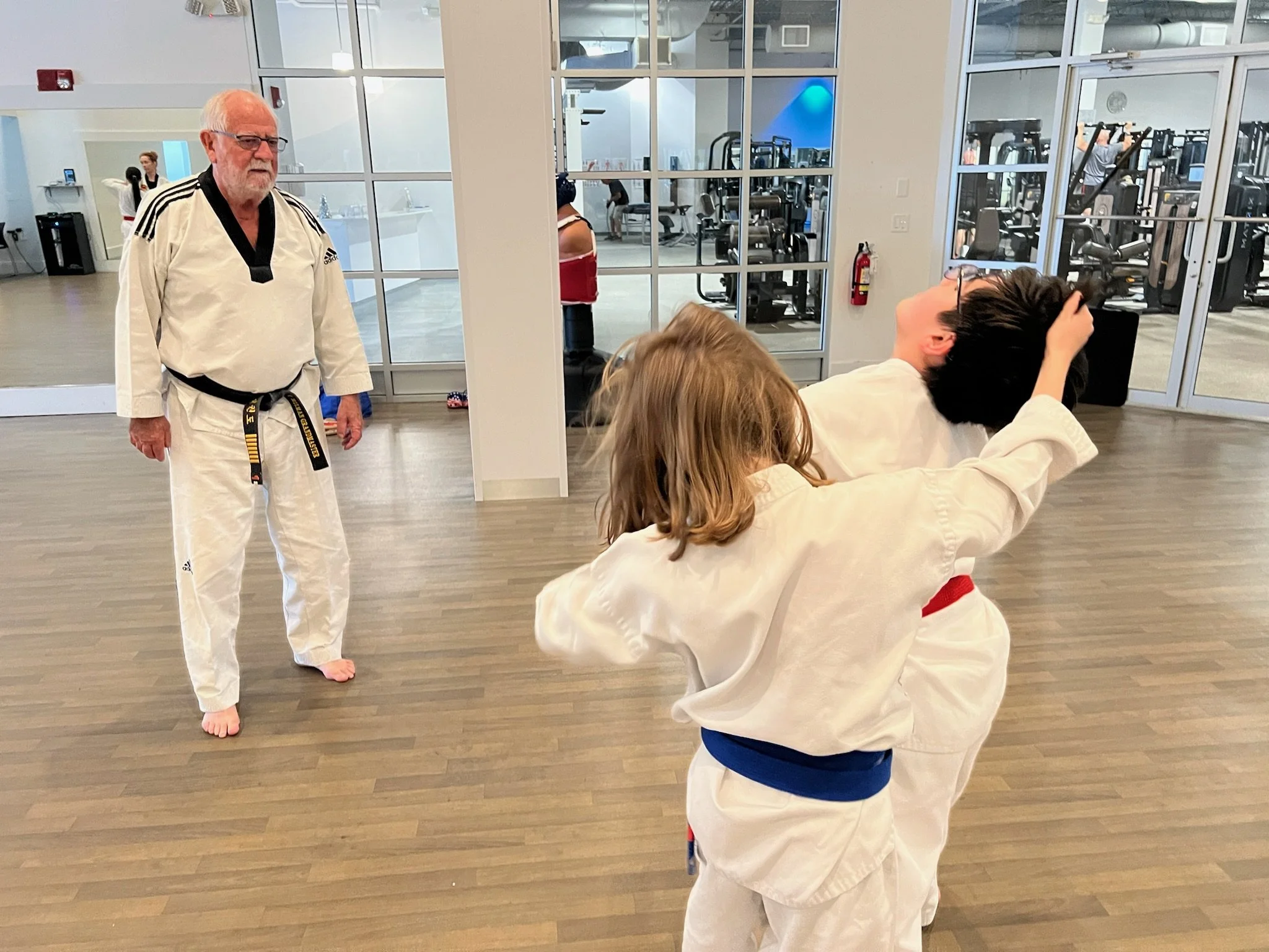 Grandmaster Milman watches two students spar at Discovery Tae Kwon Do.