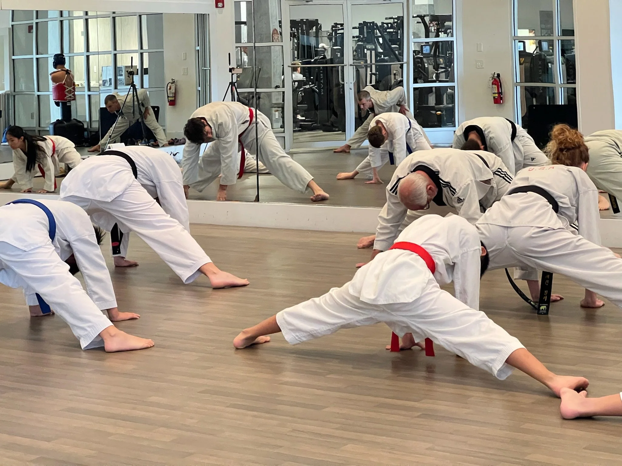 Students do split stretching with Grandmaster Milman.