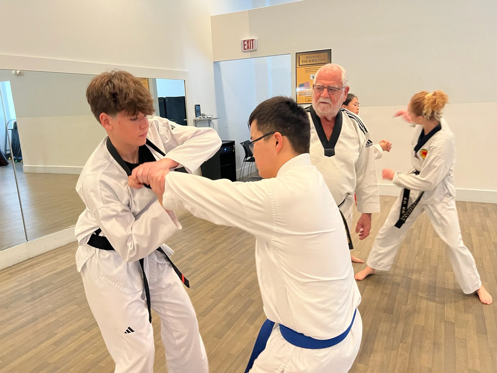 Two male students spar while Grandmaster Milman gives instruction. 
