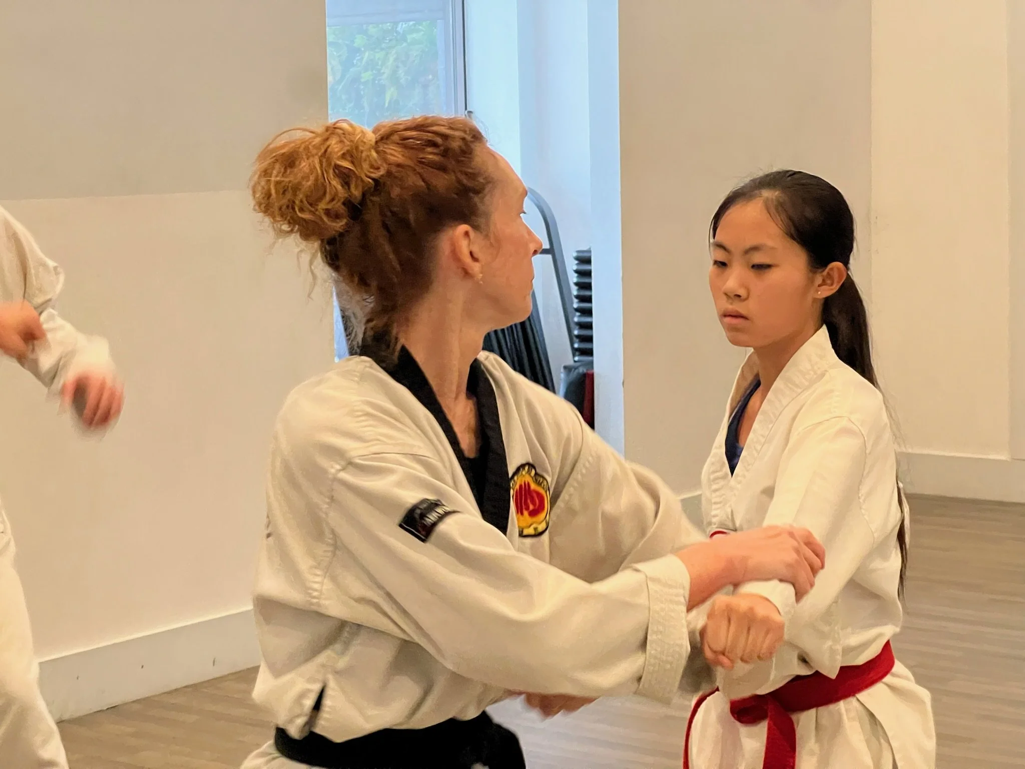 Two women spar in taekwondo class. 