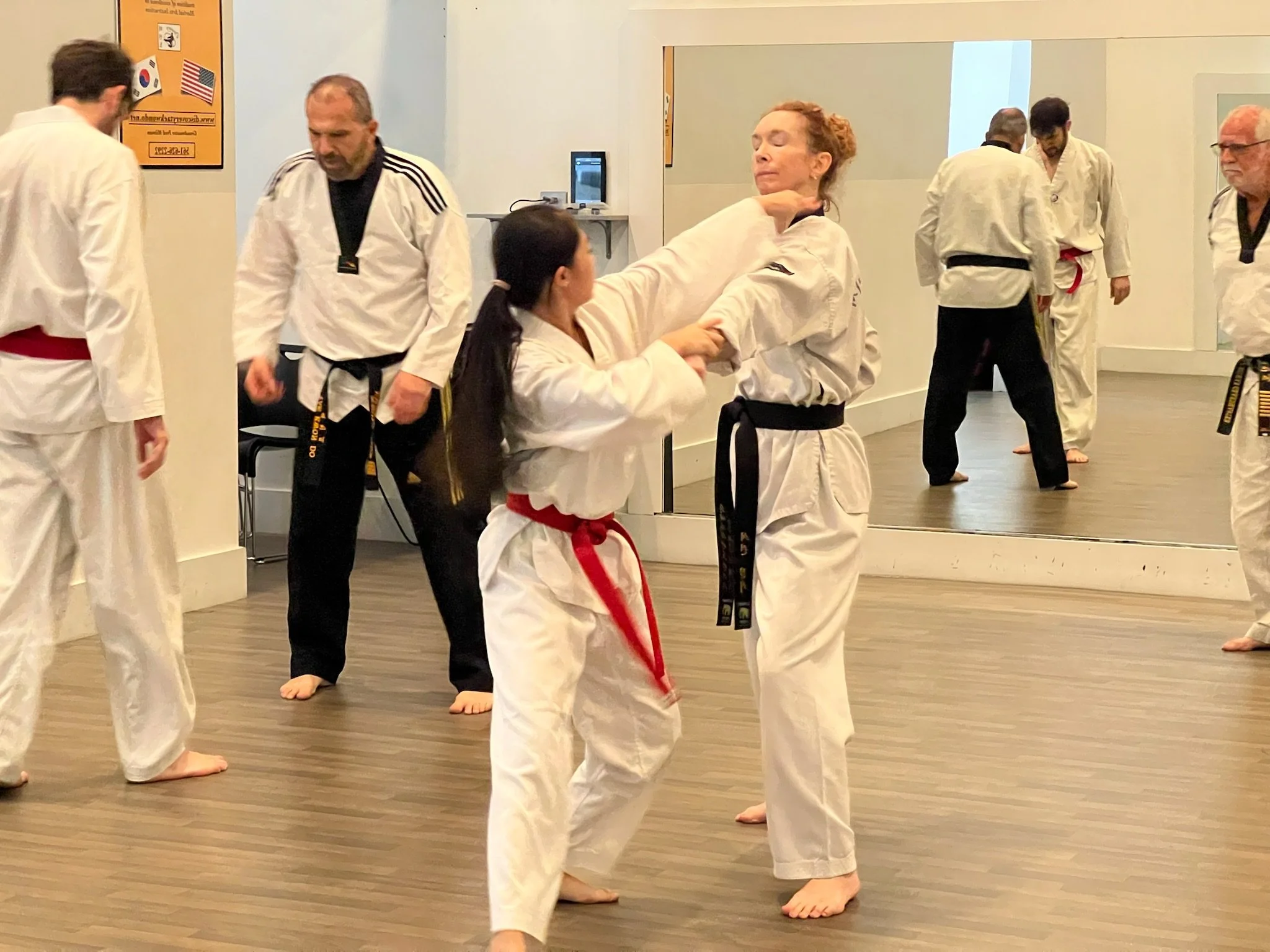 Two women spar in Discovery Tae Kwon Do class. 