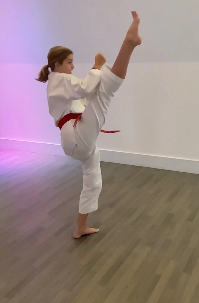 Maddie, a red belt student does a very high front kick.
