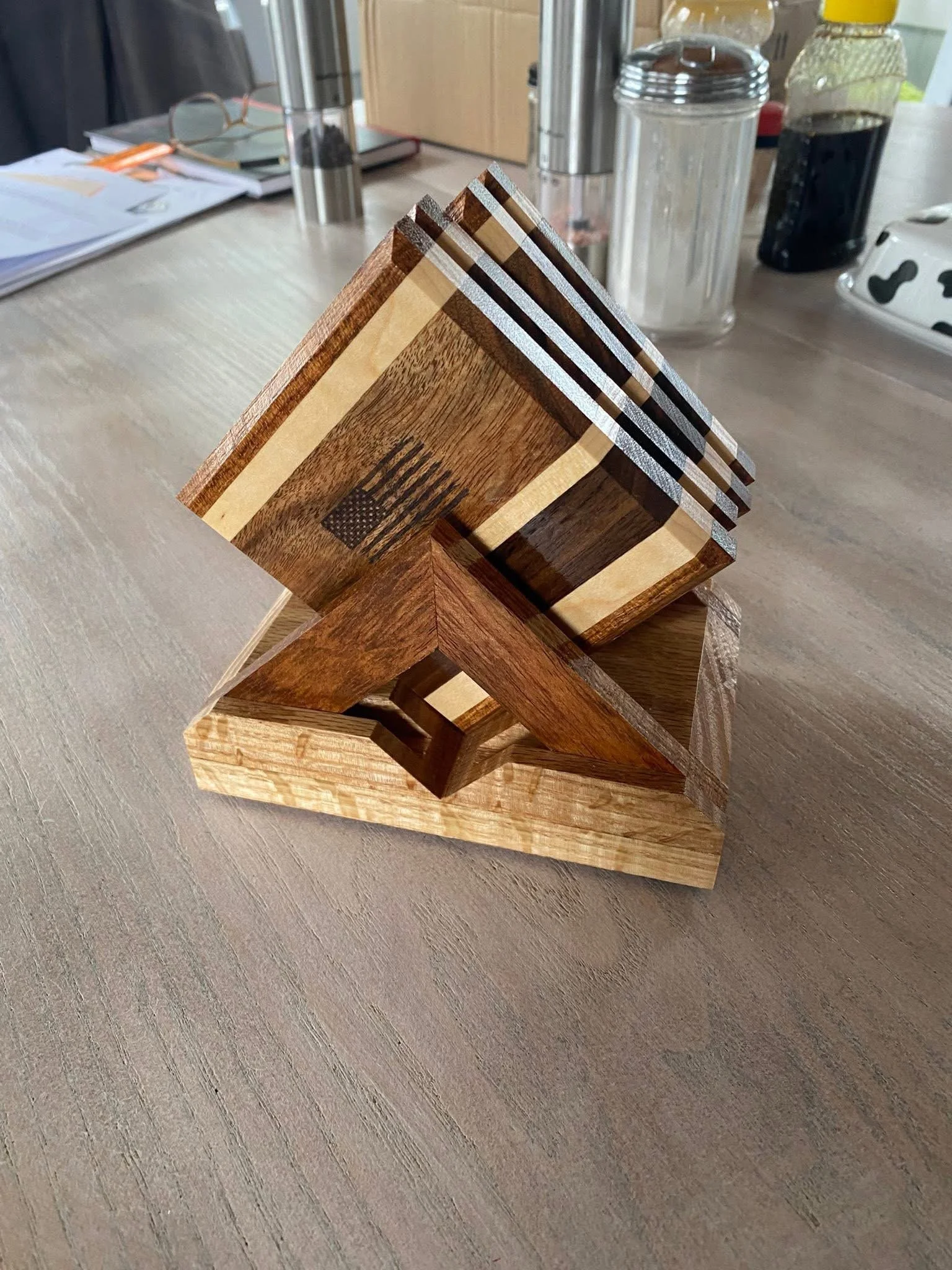 A wooden puzzle with interlocking pieces stacked in a geometric pattern on a wooden table.