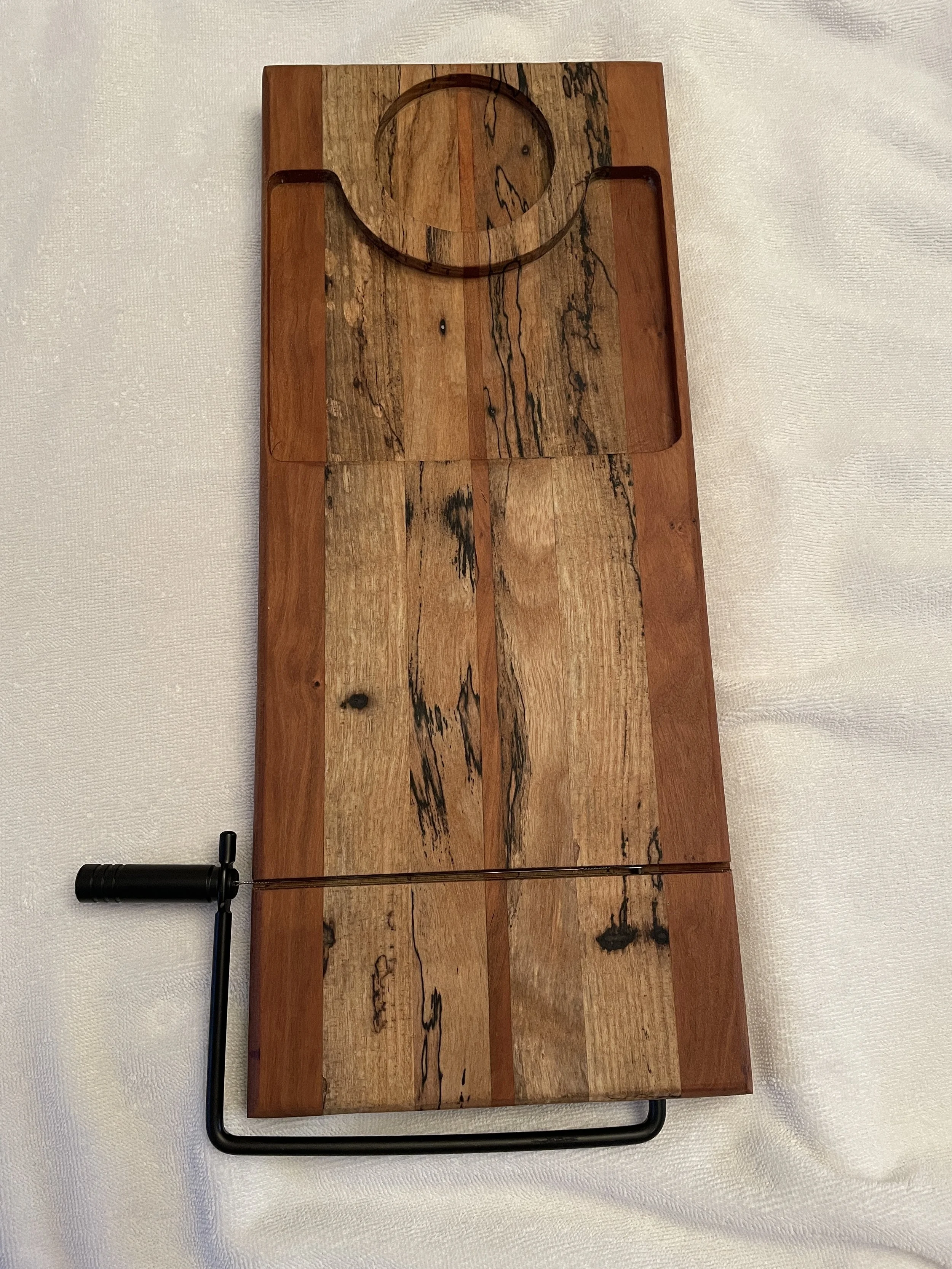 A wooden shuffleboard game with a circular scoring area at one end, a sliding puck, and a metal handle for sliding the puck.