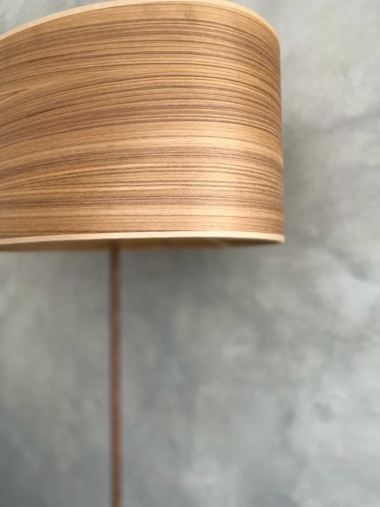 Close-up of a wooden lampshade with curved horizontal lines.