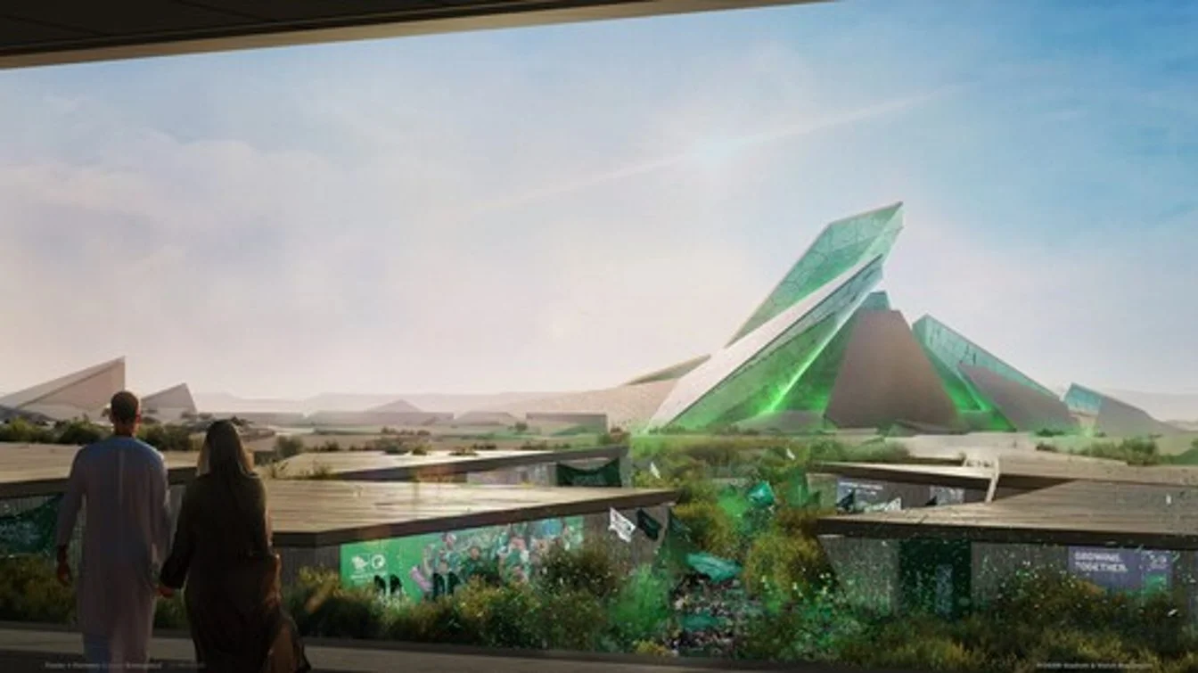 Futuristic architecture with angular green and gray buildings and a garden in the foreground, two people walking.