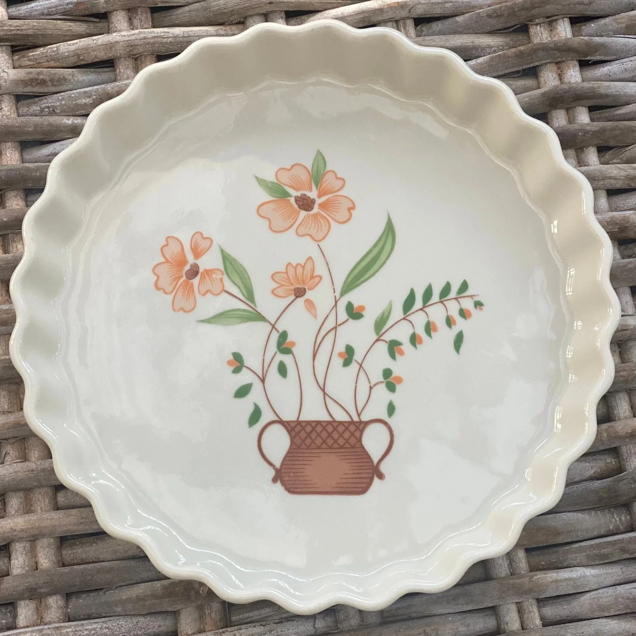 Top-down view of stoneware pie dish showing floral motif and ruffled edge