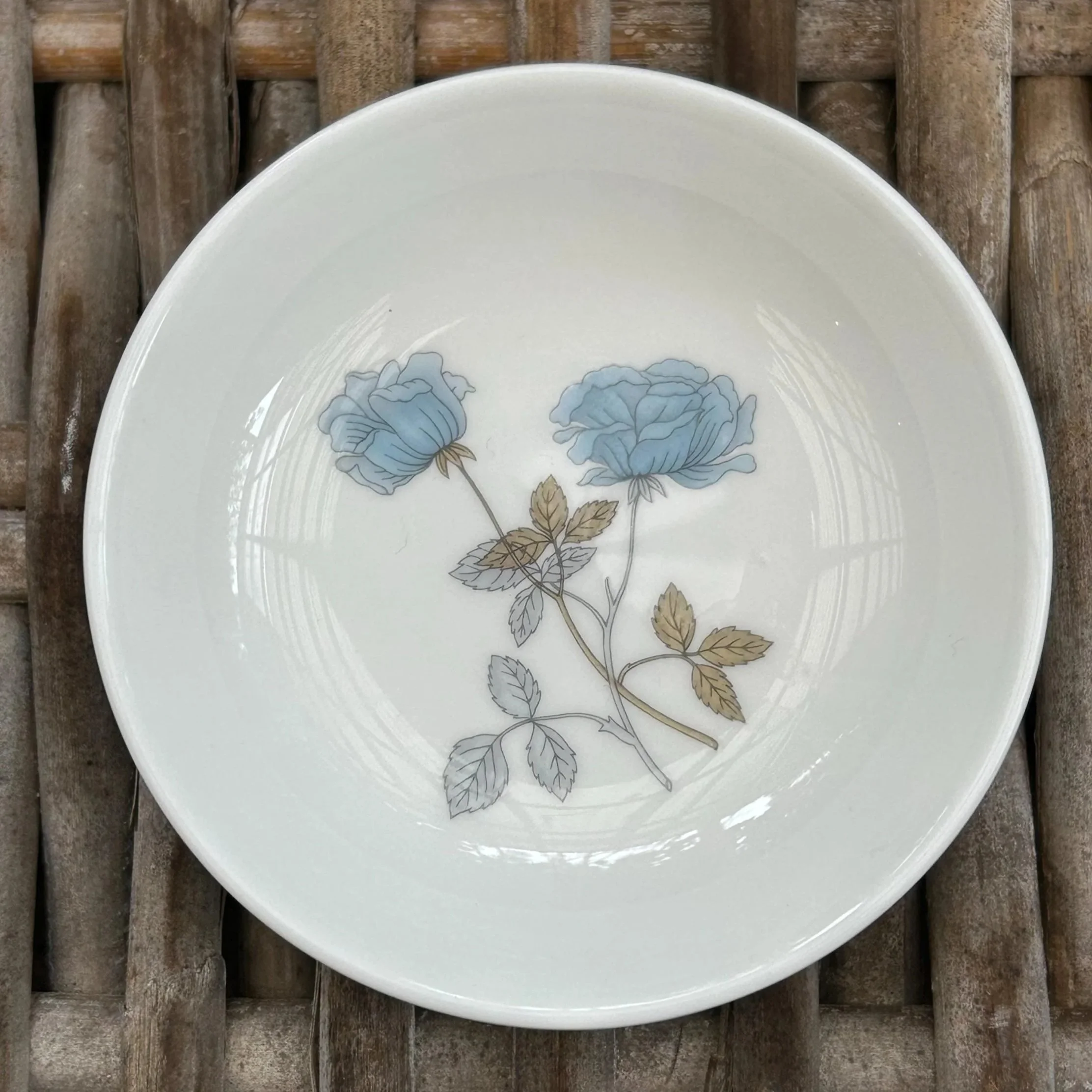 Top view of the Wedgwood Ice Rose dish on a wicker background, highlighting the floral pattern and clean rim