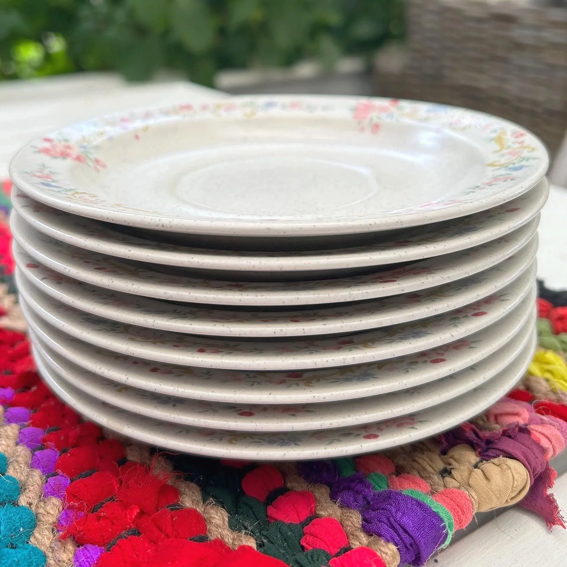 Side view of all 8 saucers stacked in a neat pile outdoors