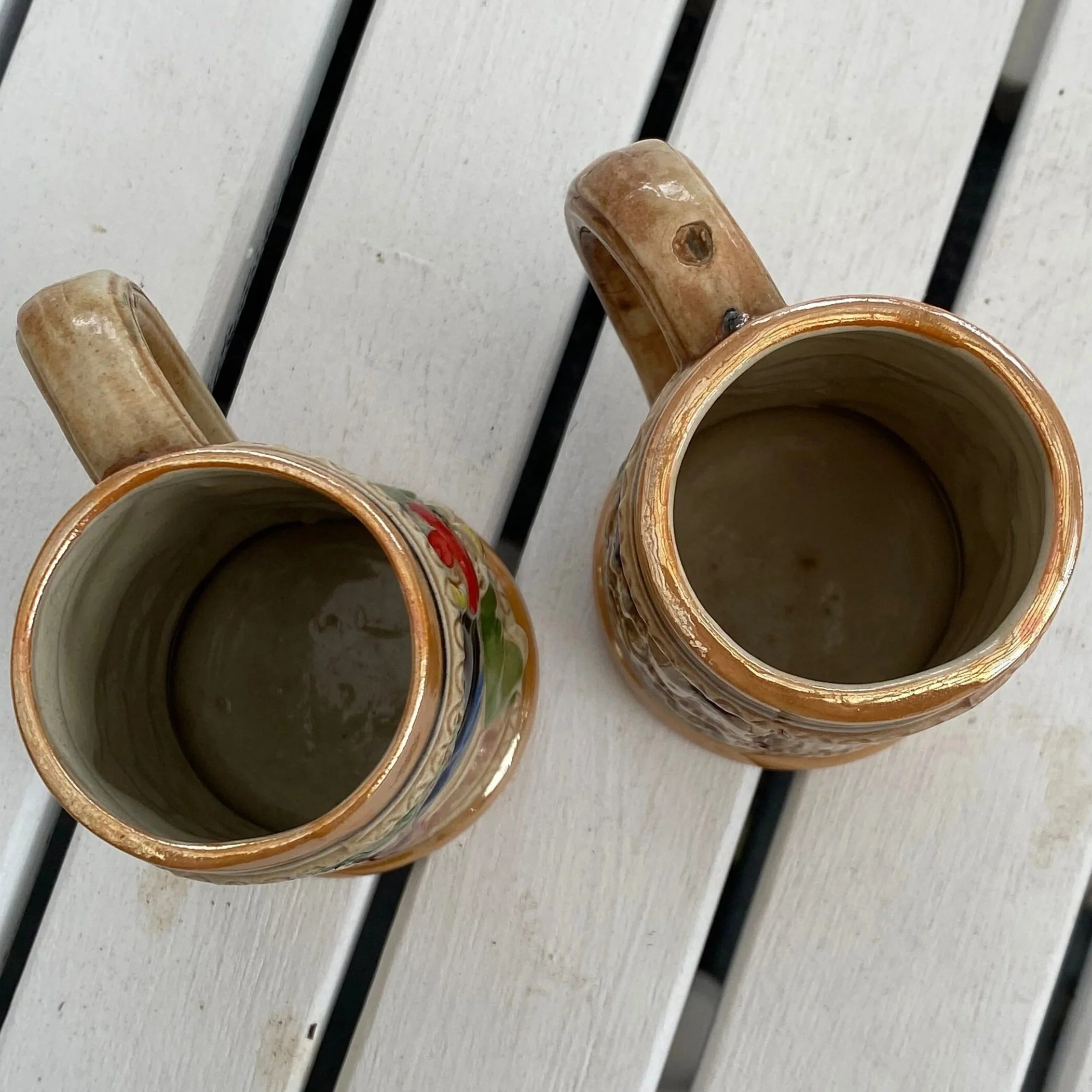 Top-down view of both tankards showing interior glaze and handle shape.