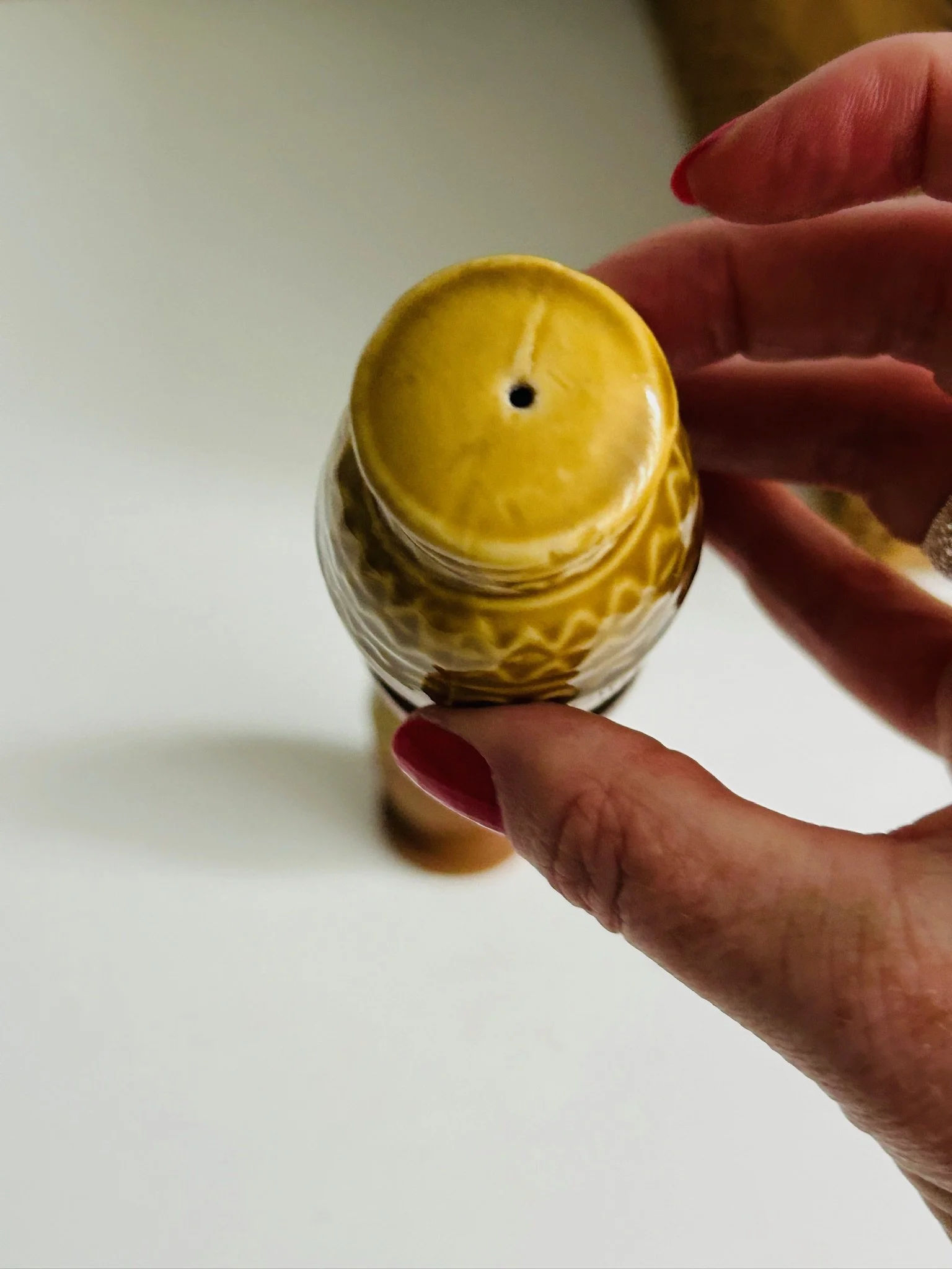 Top view of one shaker showing the shaker holes in the yellow ceramic lid