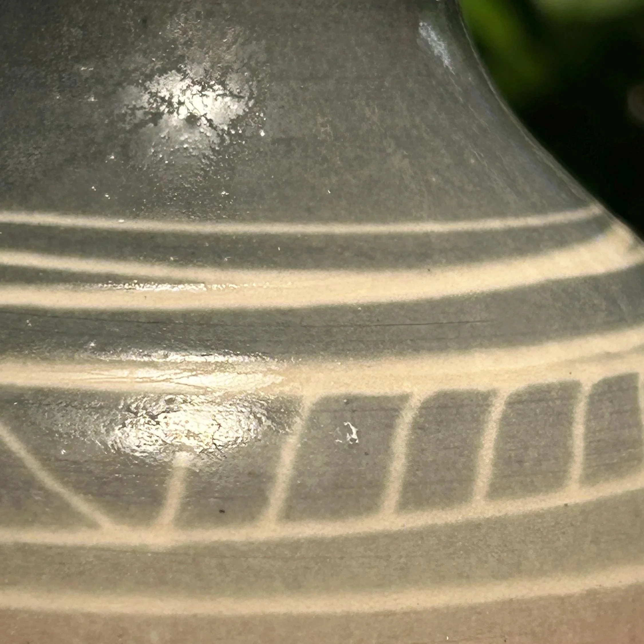 Close-up of striped detail in white over soft grey glaze