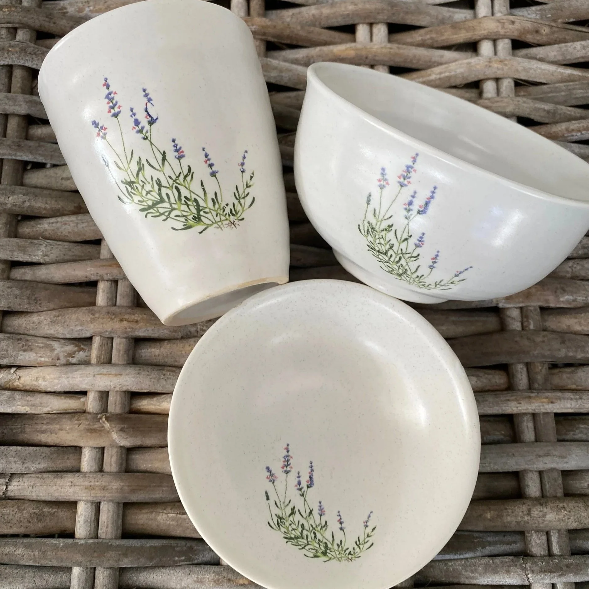 Overhead view of the three-piece ceramic set showing the hand-painted lavender motif on each piece