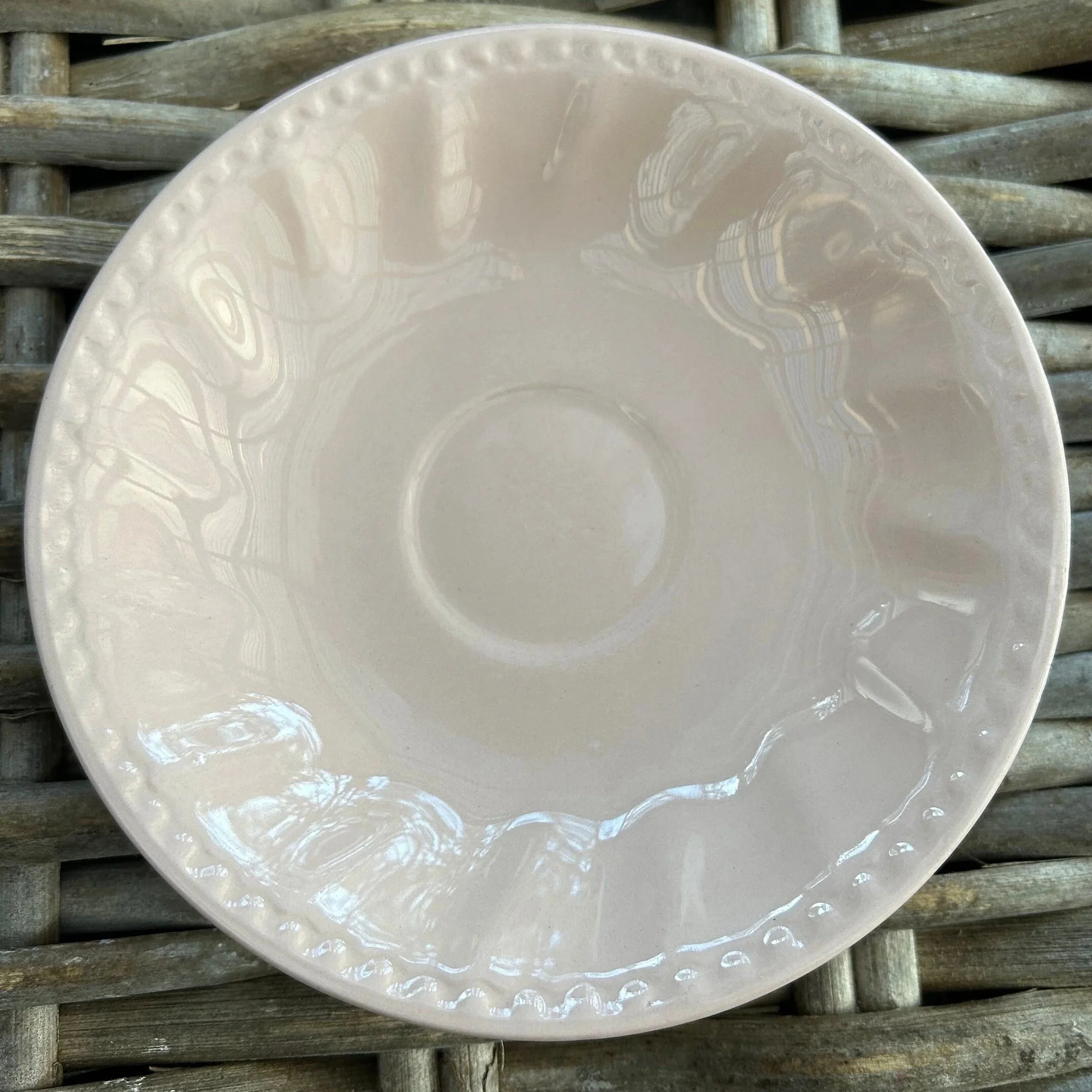 Saucer close-up showing raised rim detailing and central well