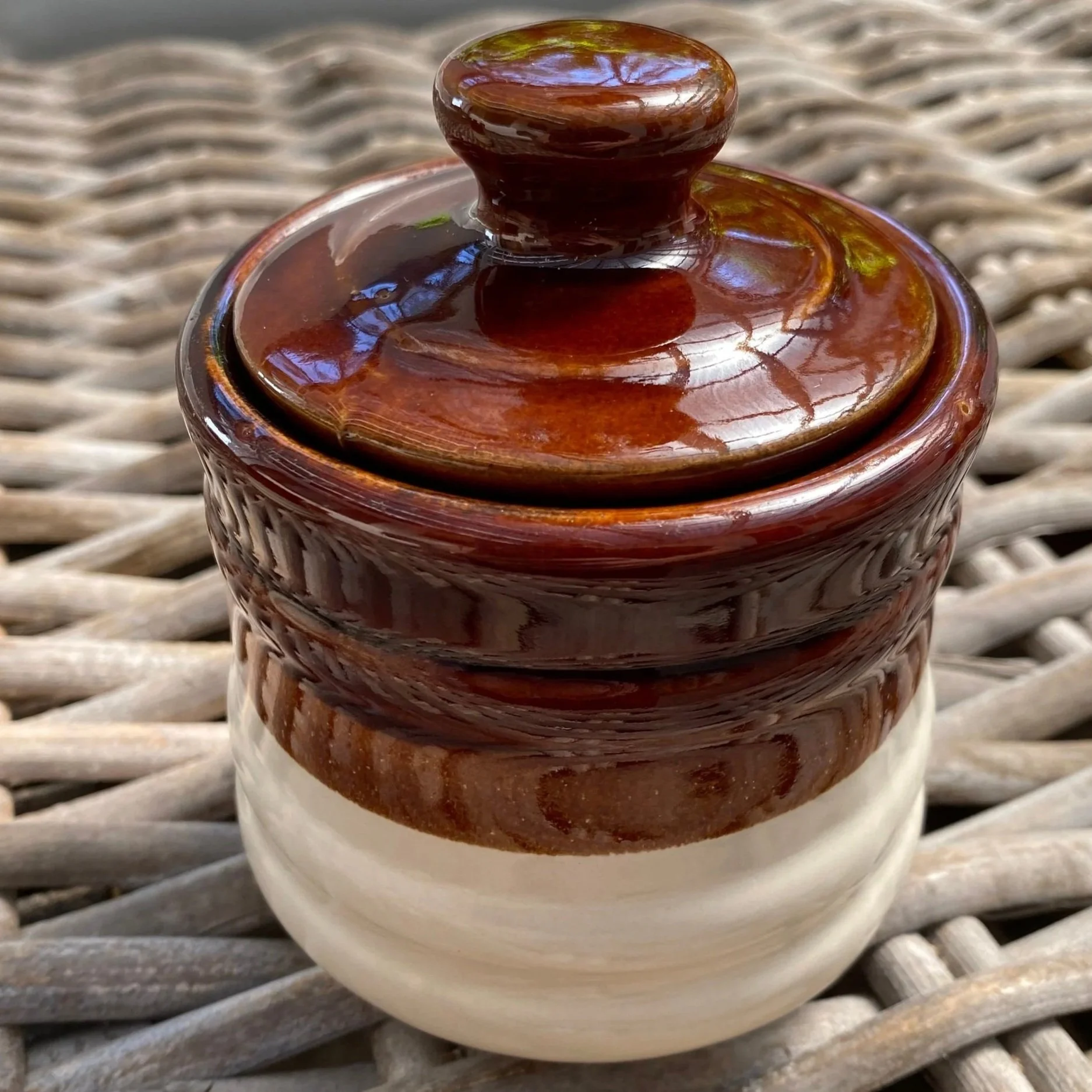 Lidded sugar bowl shown upright with visible brown and cream glaze