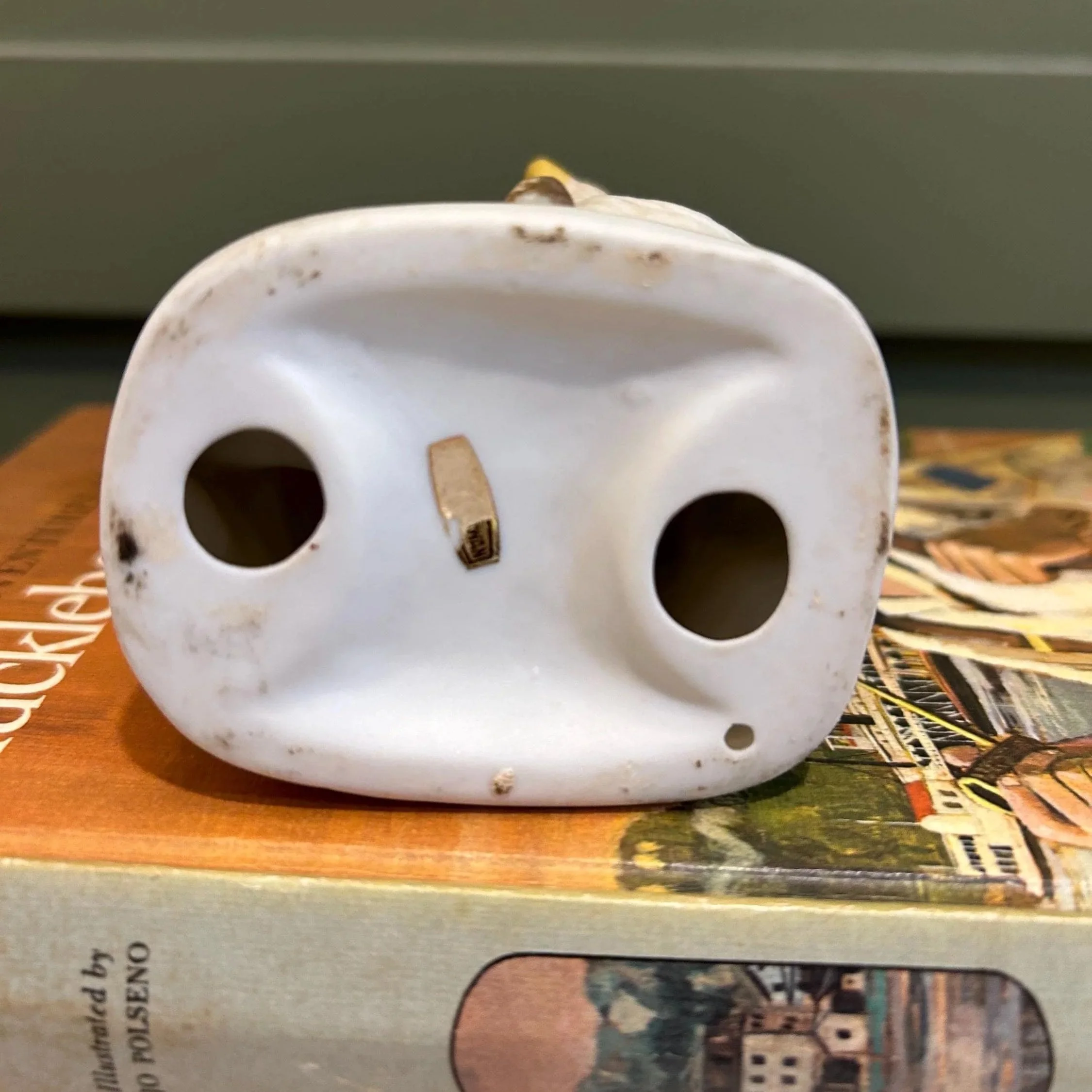 Underside showing unglazed ceramic base with hole and vent