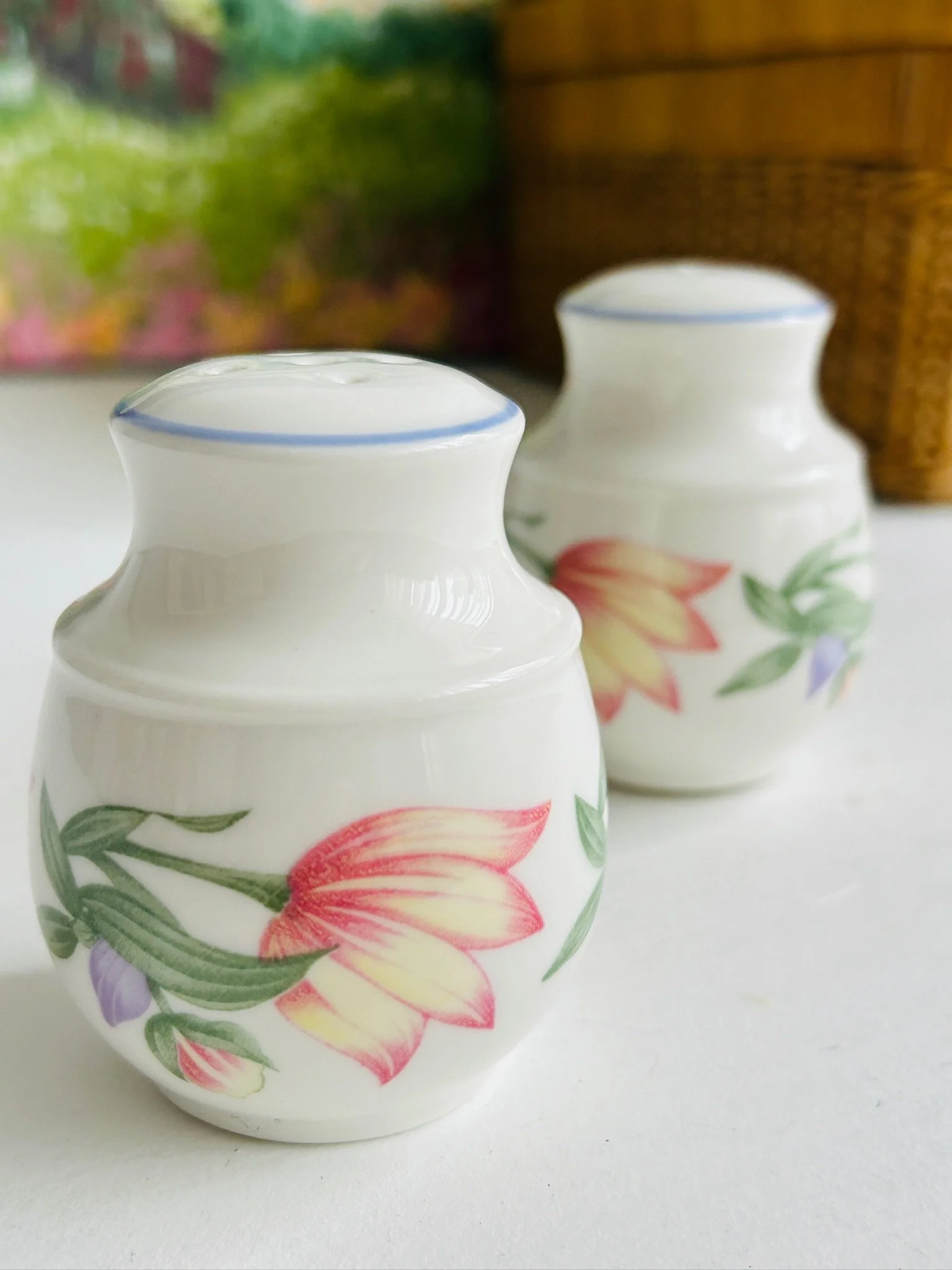 Single shaker in the foreground with its pair behind, showing the floral design and glossy finish