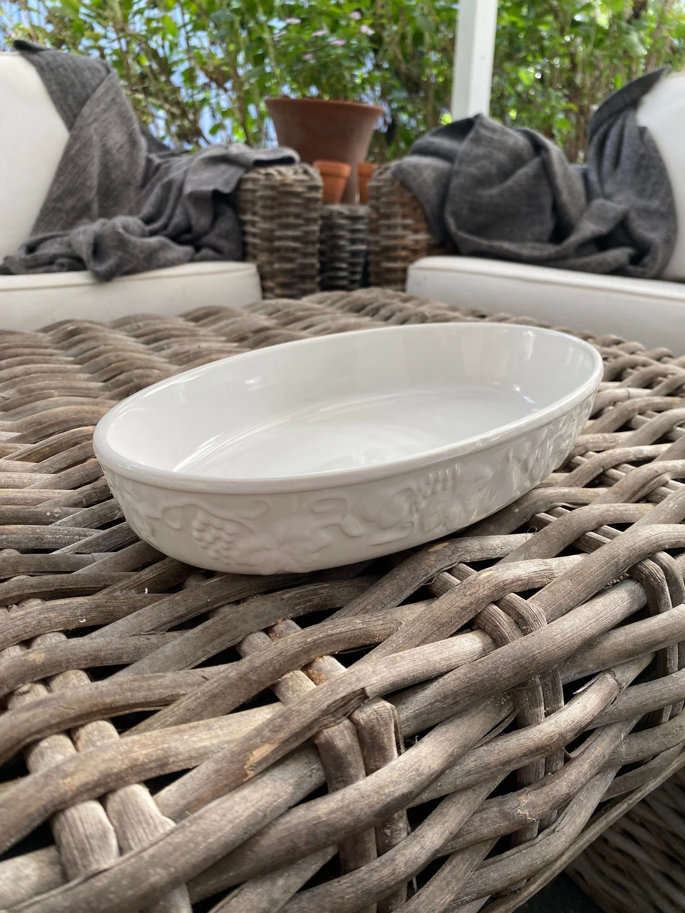 Oval baking dish displayed on woven surface