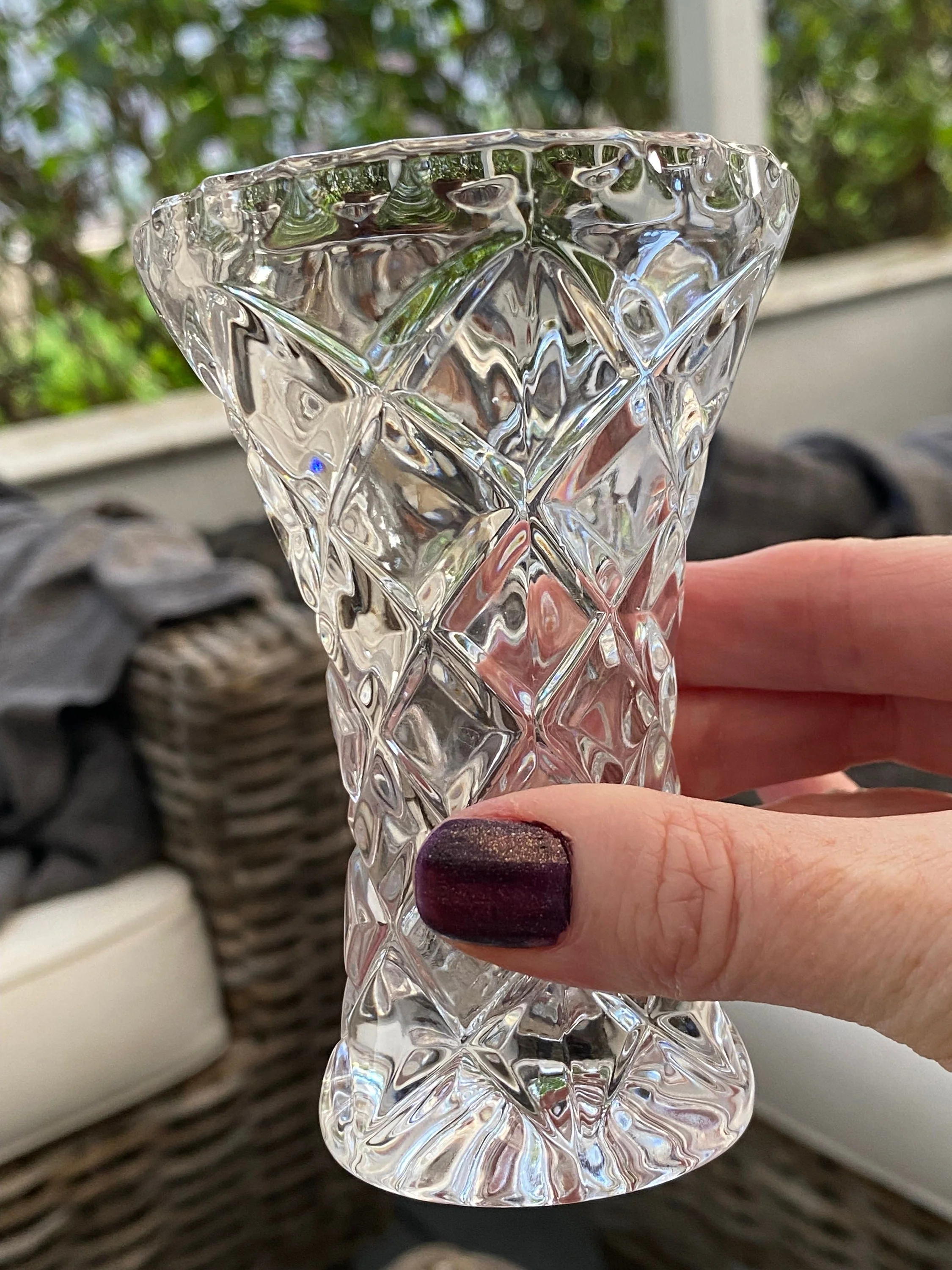 Hand-held view of the vase showing its size, sparkle, and detailed cut-glass surface