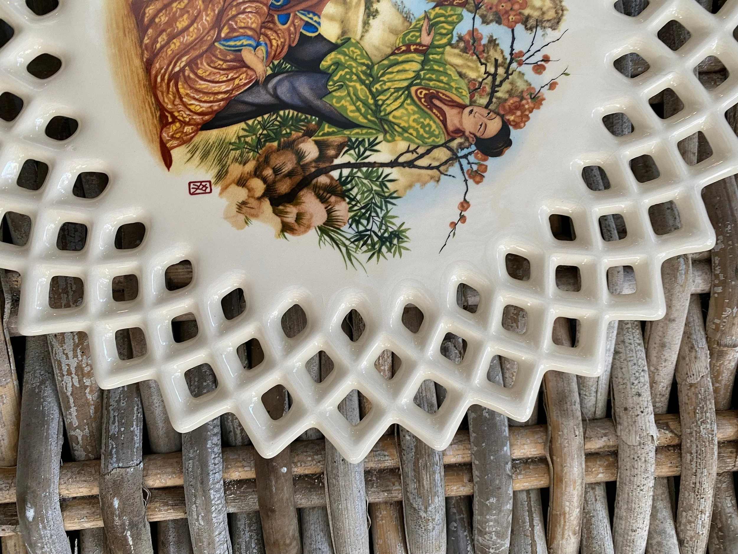 Close-up of reticulated rim detail and painted figural design