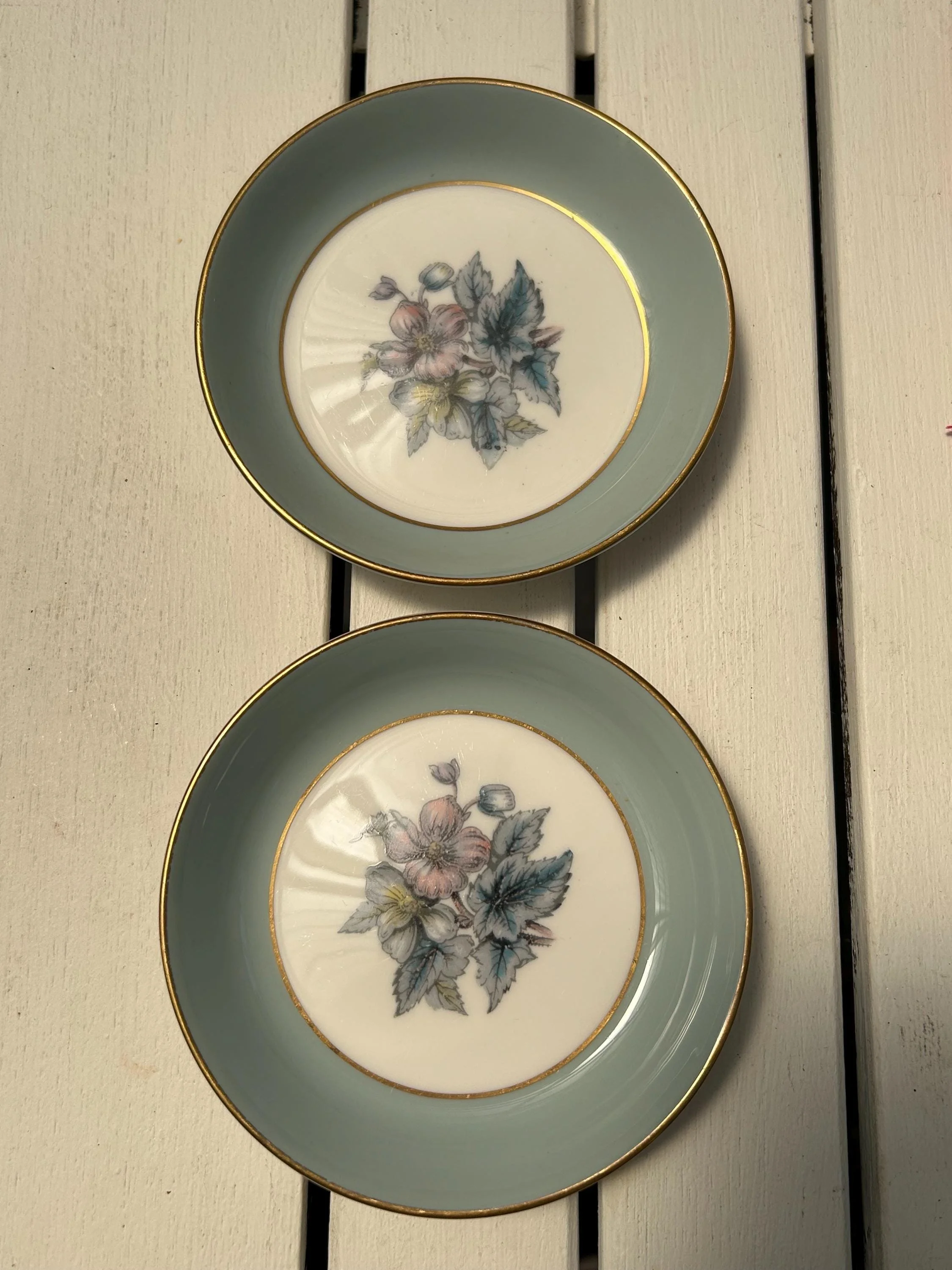 dishes against white wood background, floral designs centred