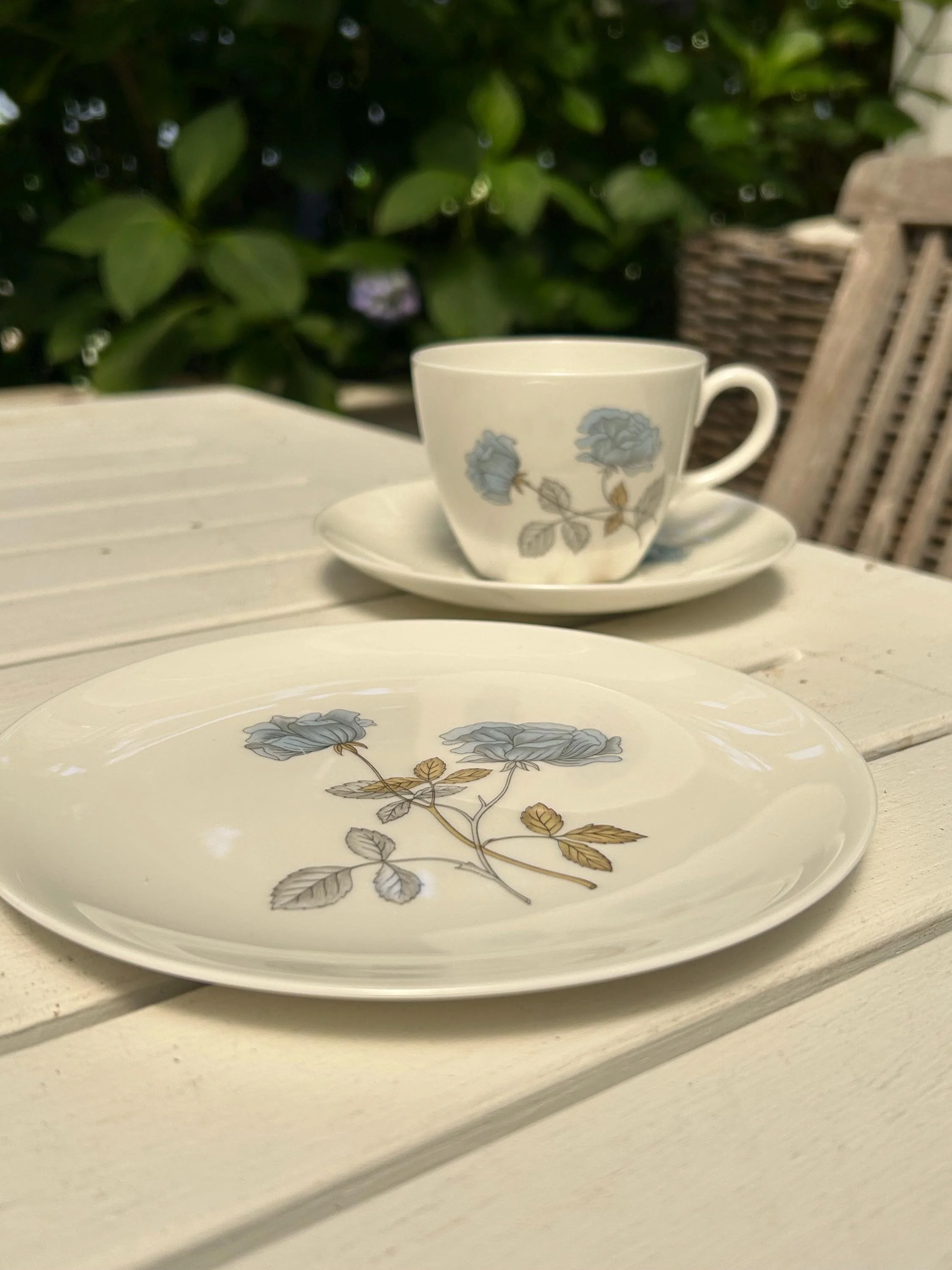 Teacup, saucer, and side plate arranged on a table, showing the full floral trio set together