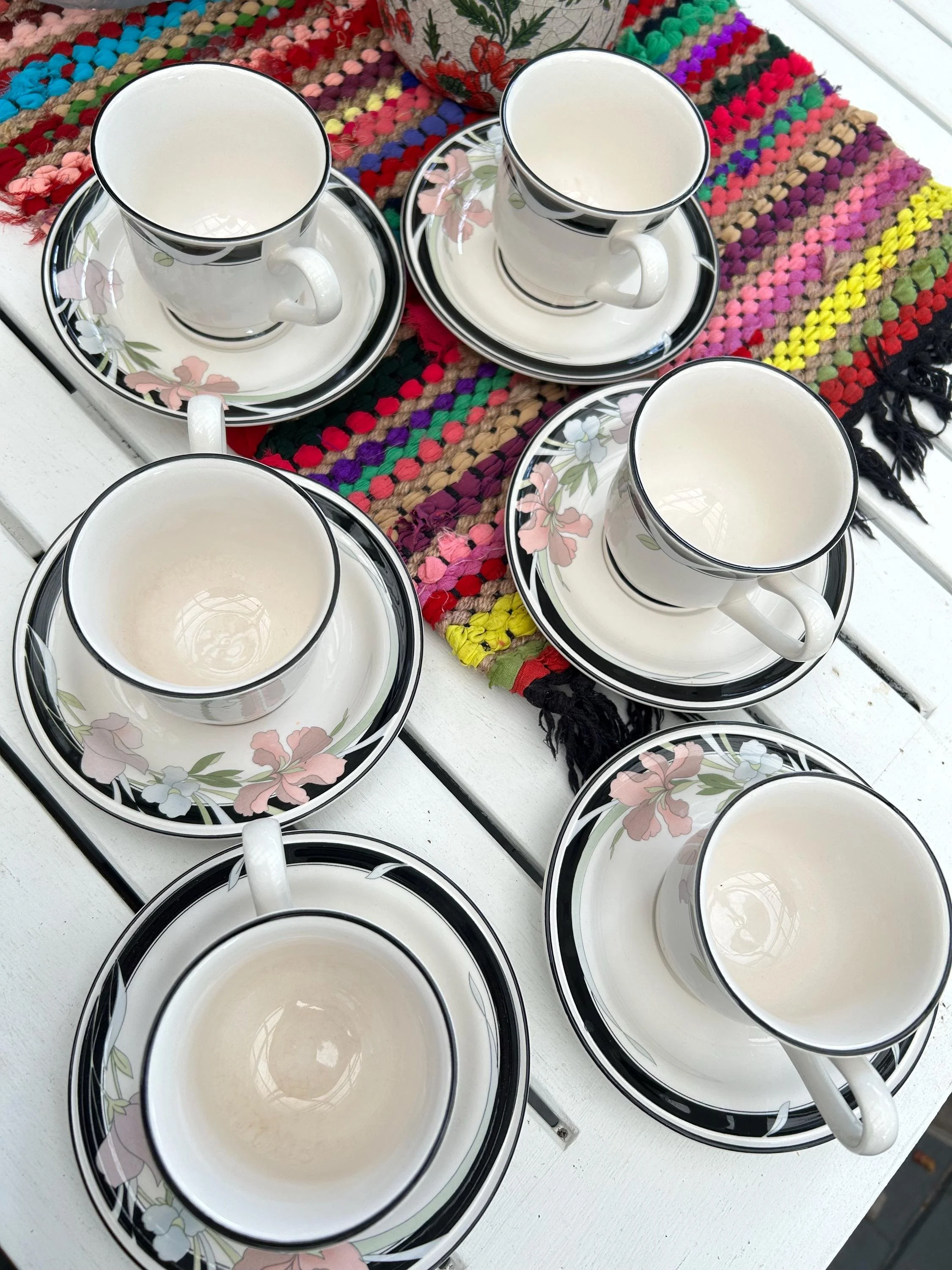 Overhead of all six sets arranged on a colourful textile