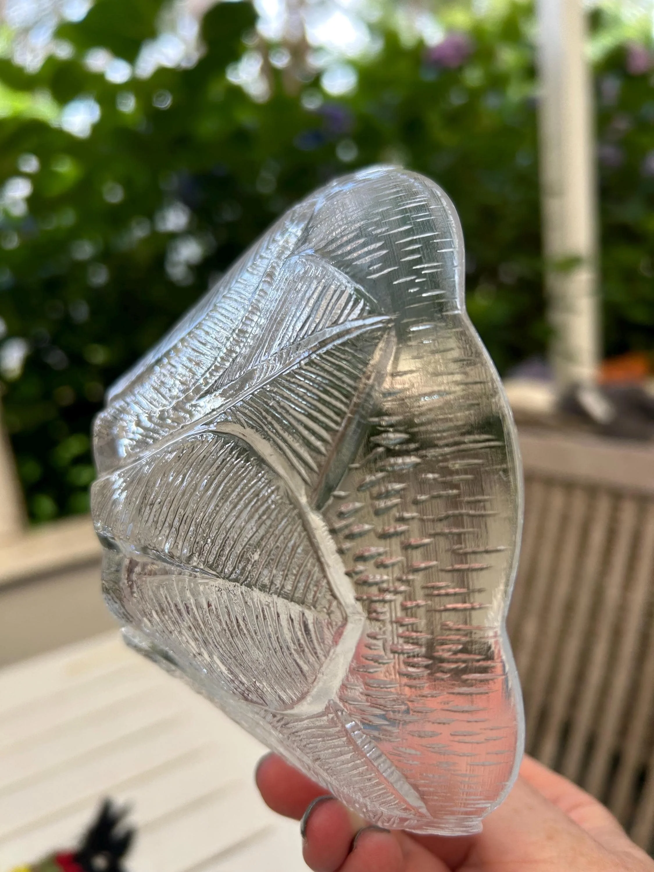 Side profile of one crystal bowl showing the curved petal form and textured glass surface