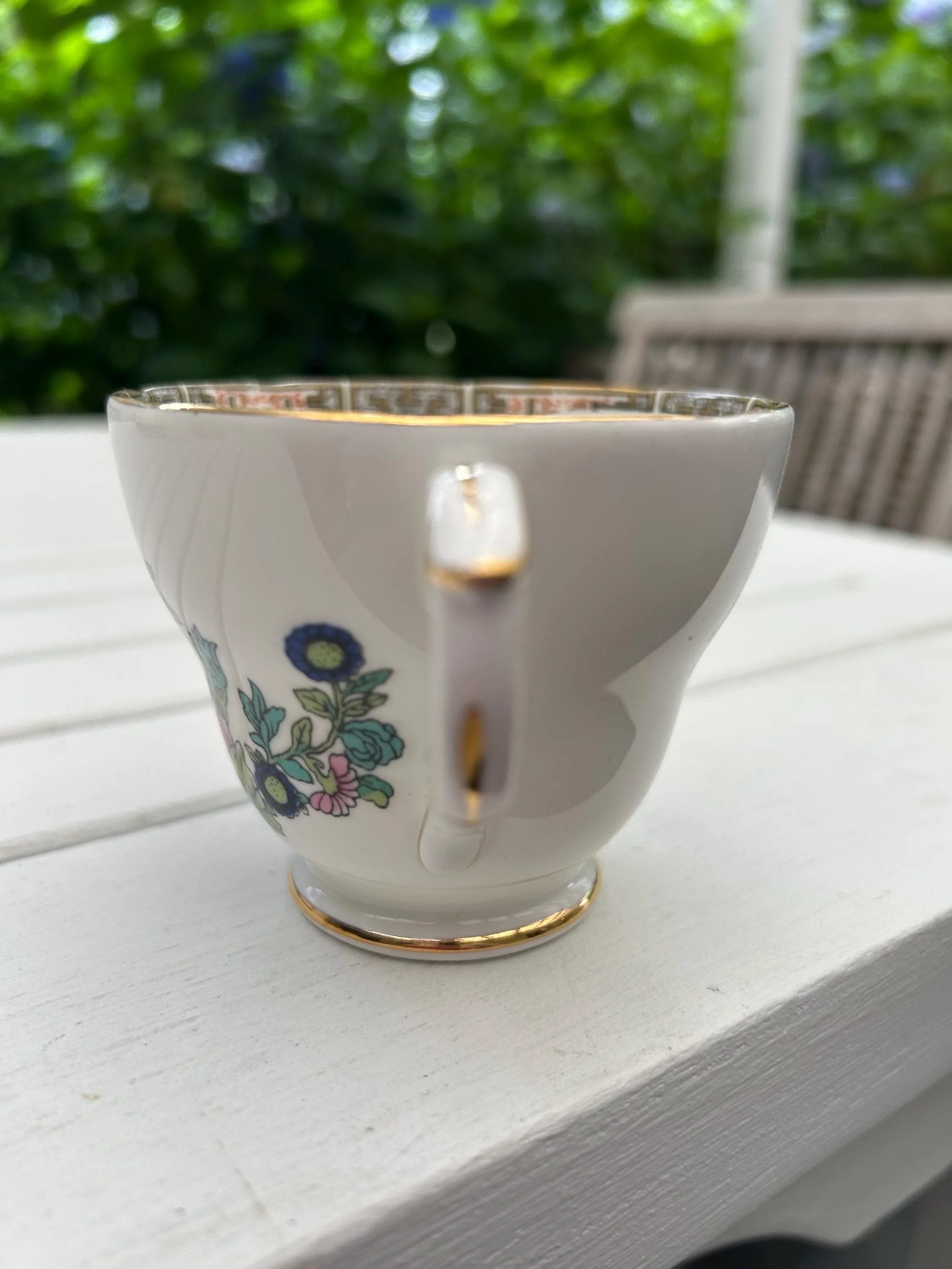 Rear view of cup with smaller floral motif and curved handle