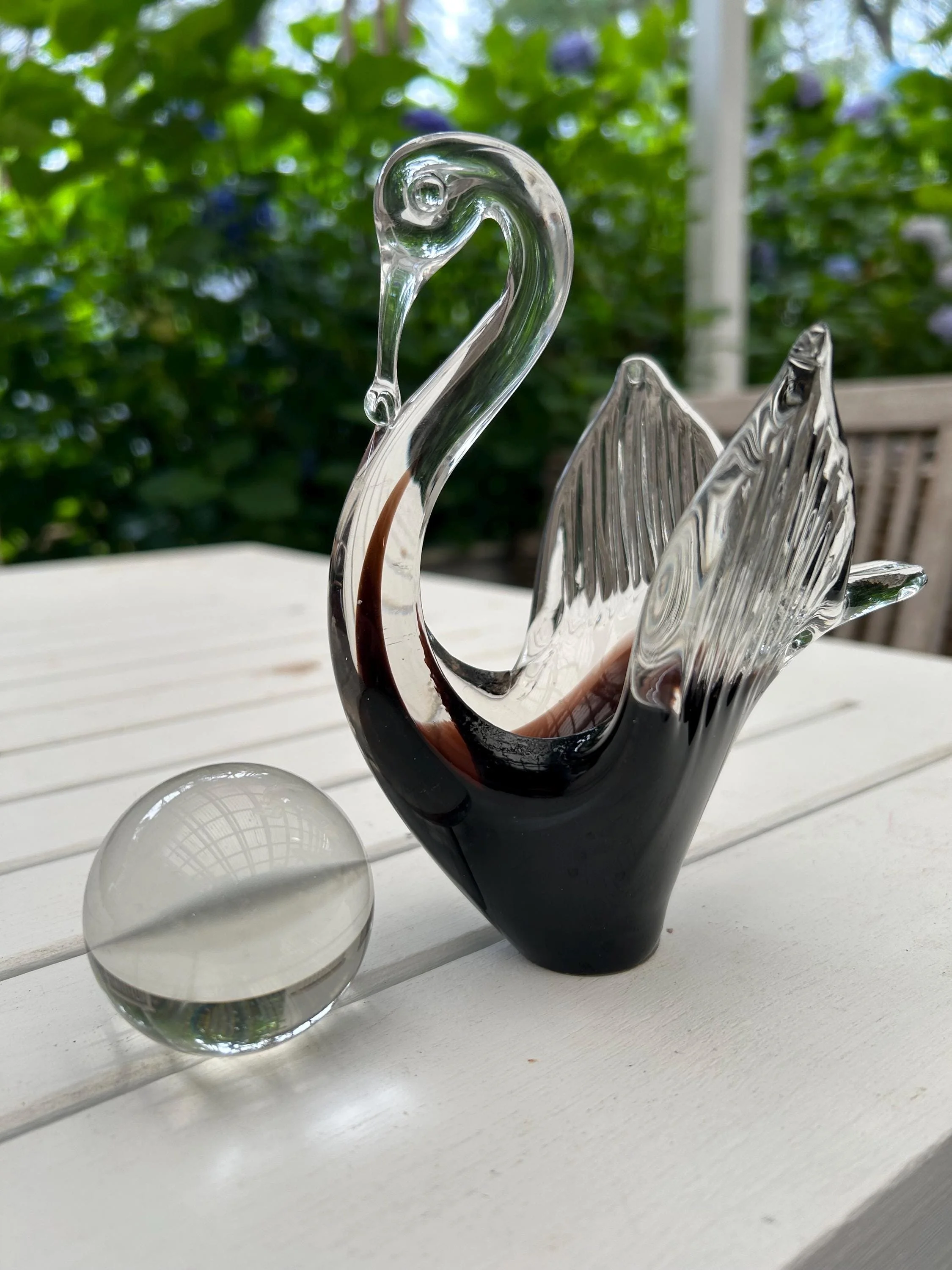 Swan and sphere displayed together on white tabletop