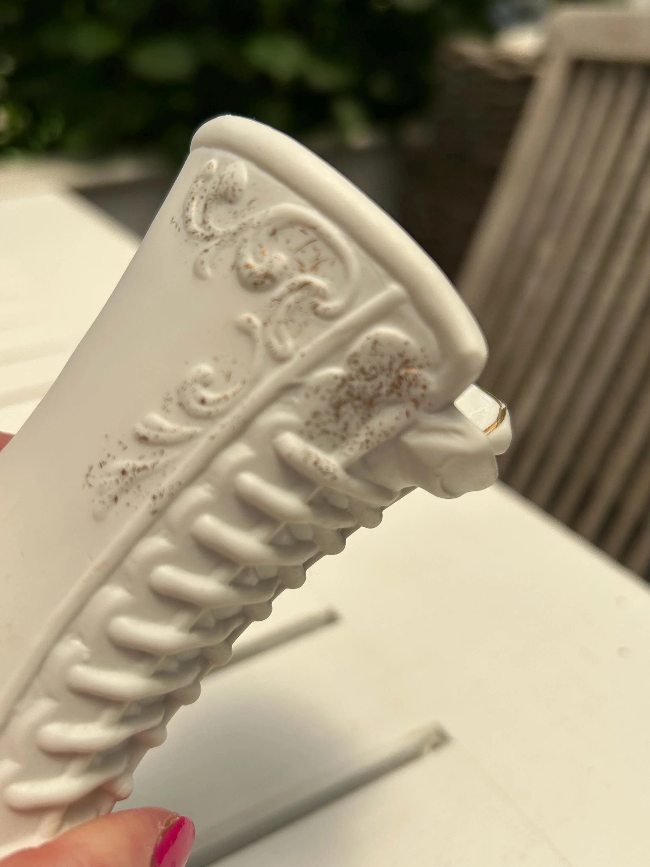 Close-up of embossed scrollwork and gold filigree near top rim