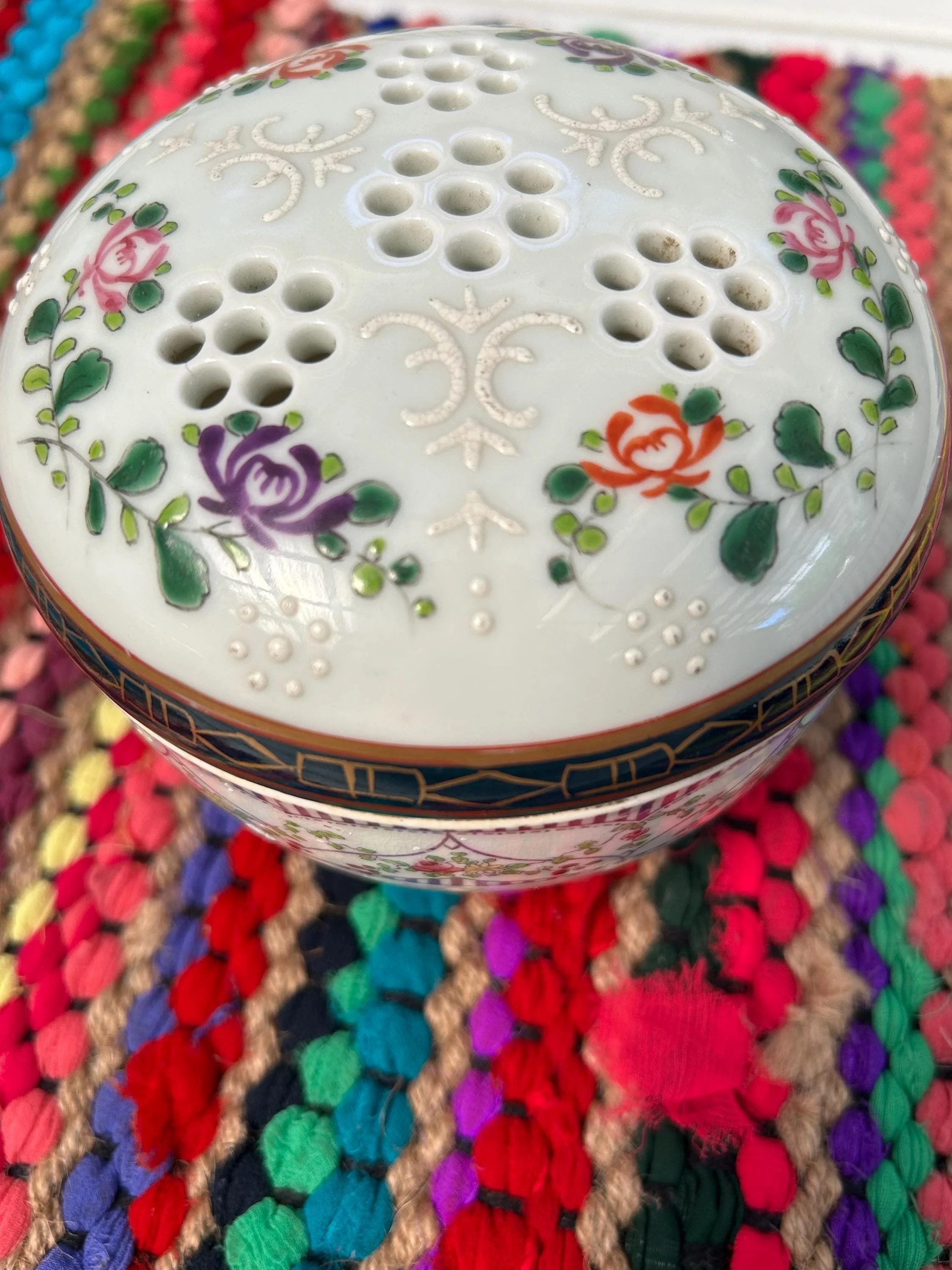 Close-up of floral lid pattern with rose detail and gold edging
