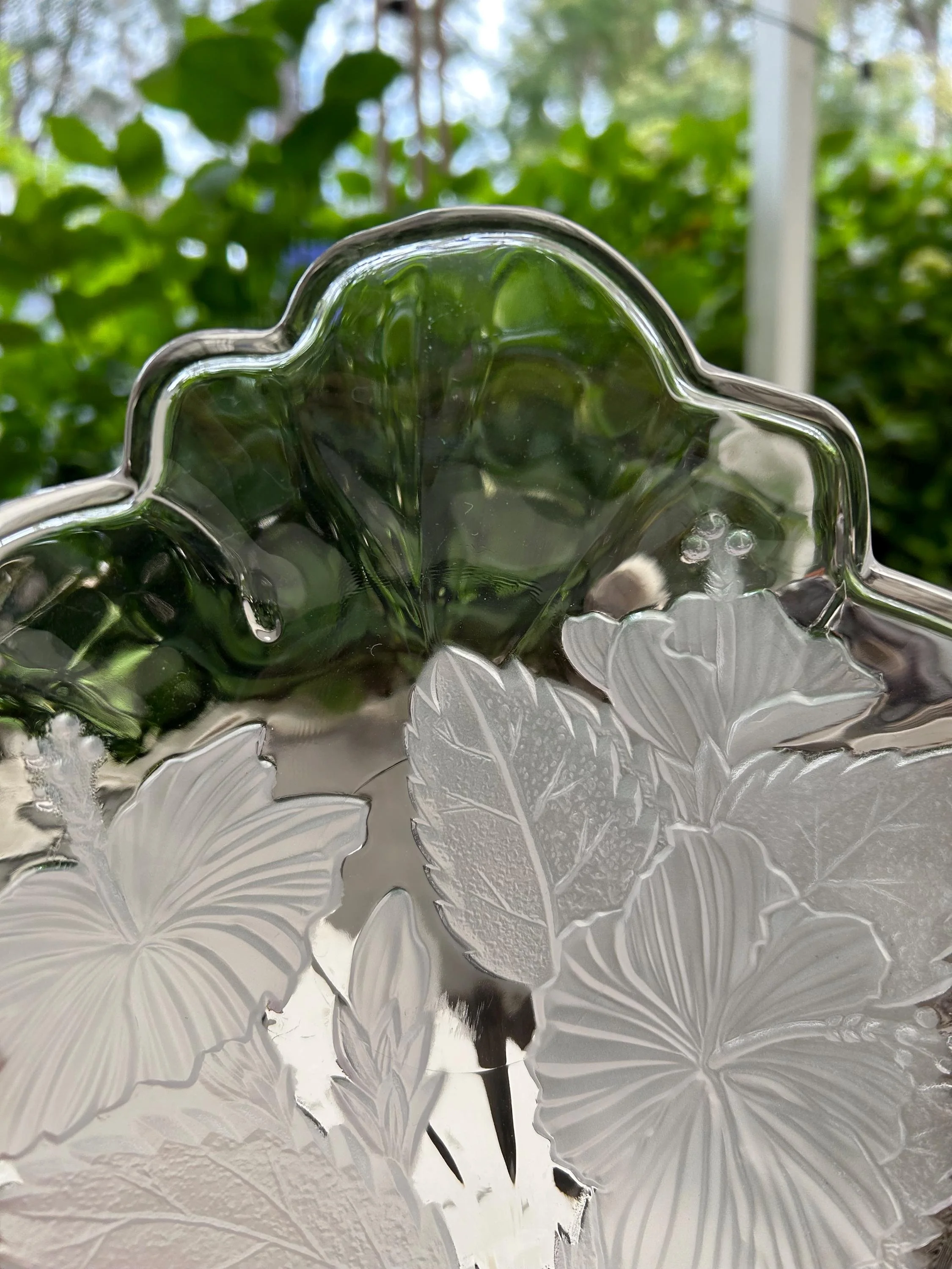 Close-up of etched leaves and hibiscus blooms in frosted relief.